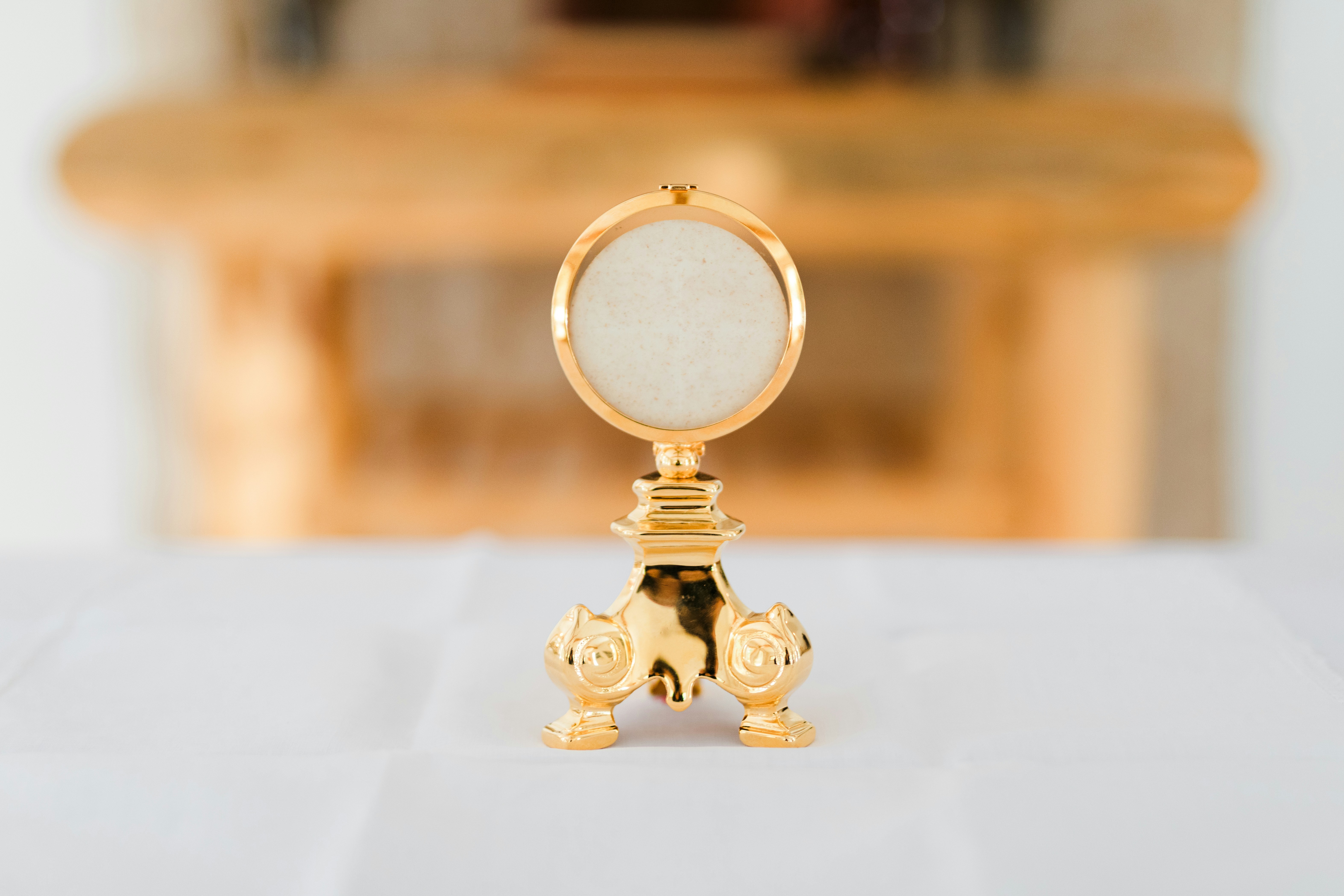 白いテーブルクロスの上に黄金の聖体が置かれています。