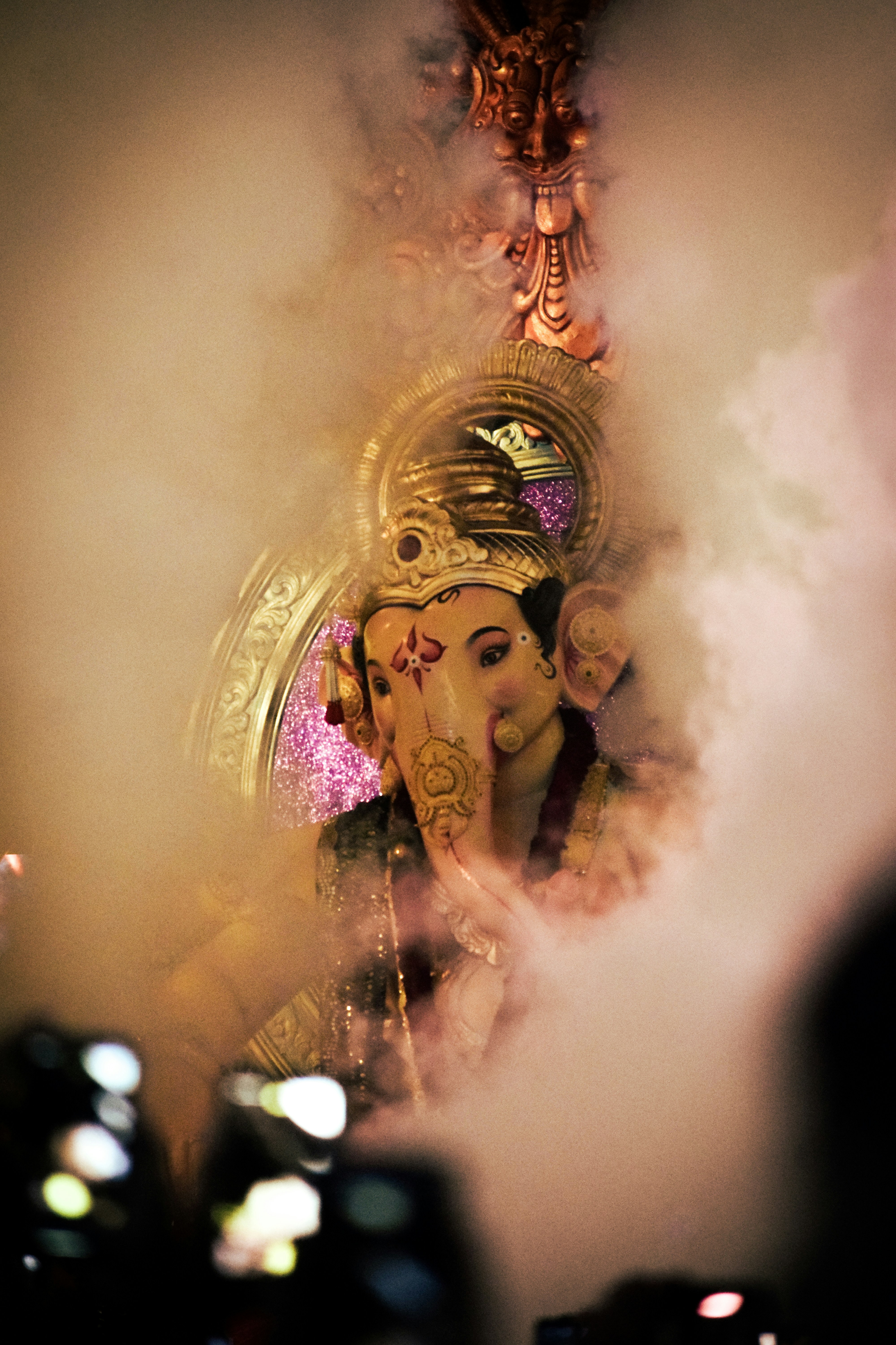 Lord ganesha is seen through smoke.