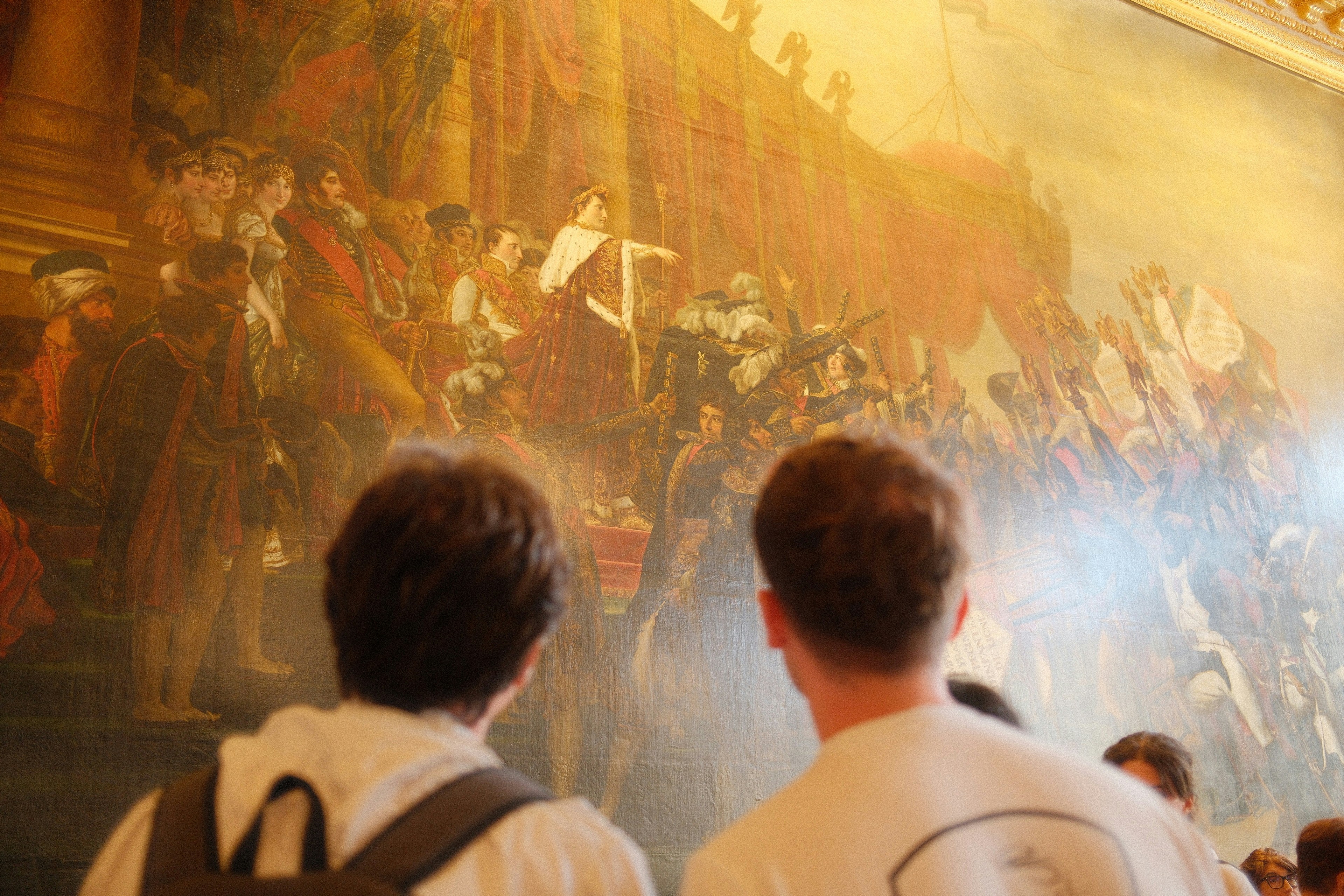 Deux personnes admirent un grand tableau historique
