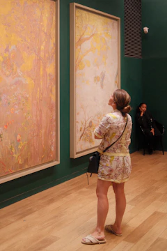 Woman admires paintings in an art gallery.