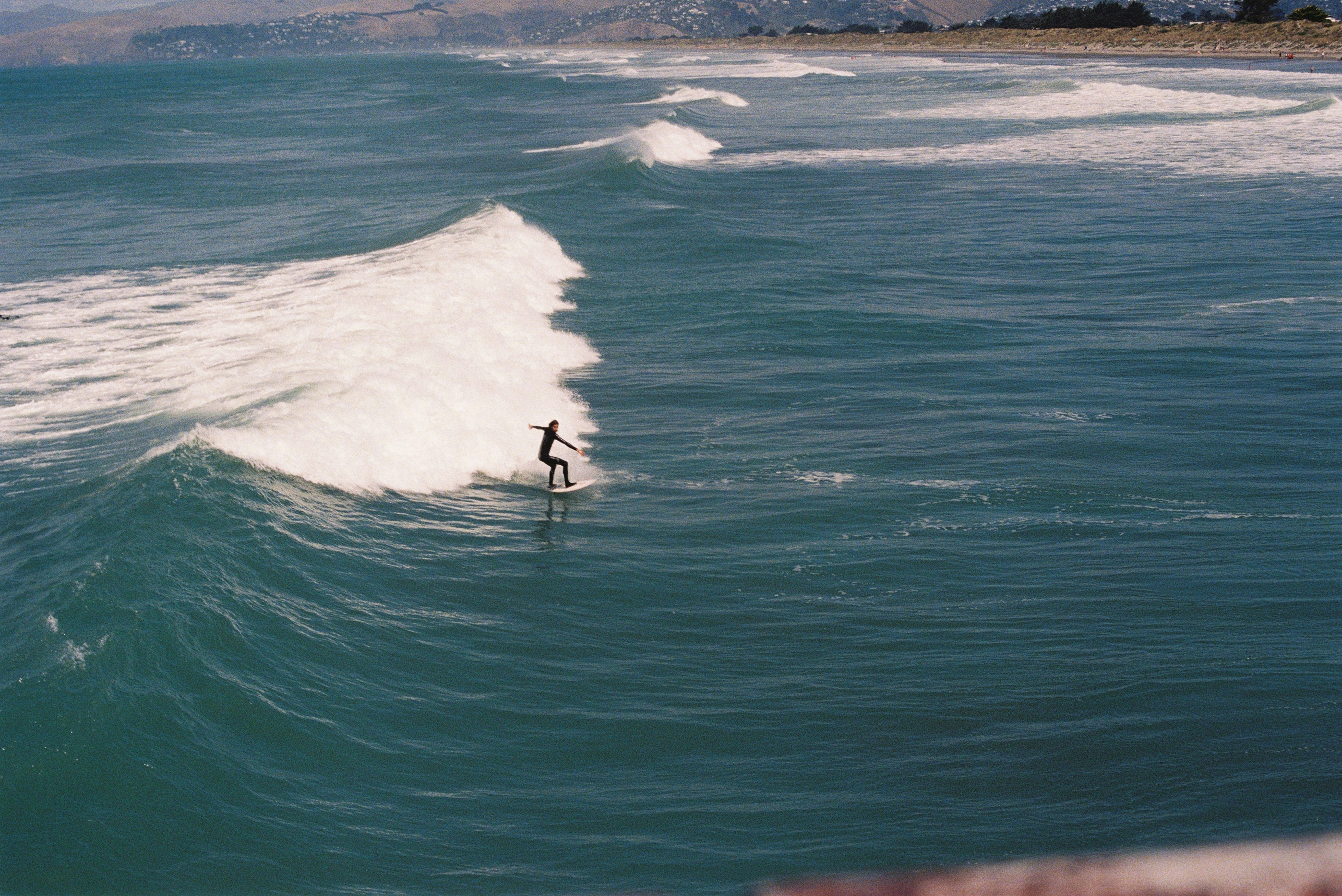 Surfer rides a wave in the blue ocean.