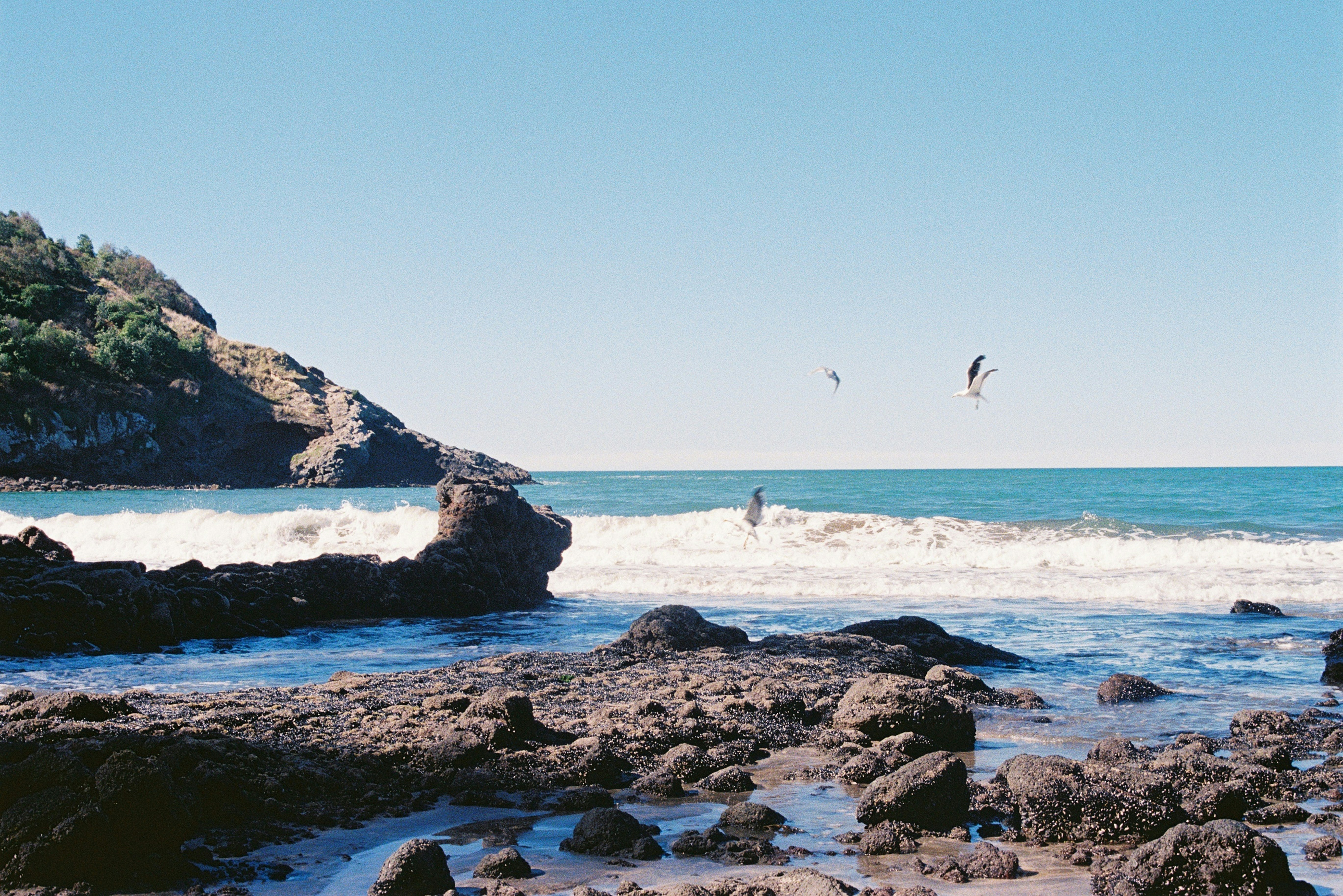 Ocean waves crash on the rocky shore.