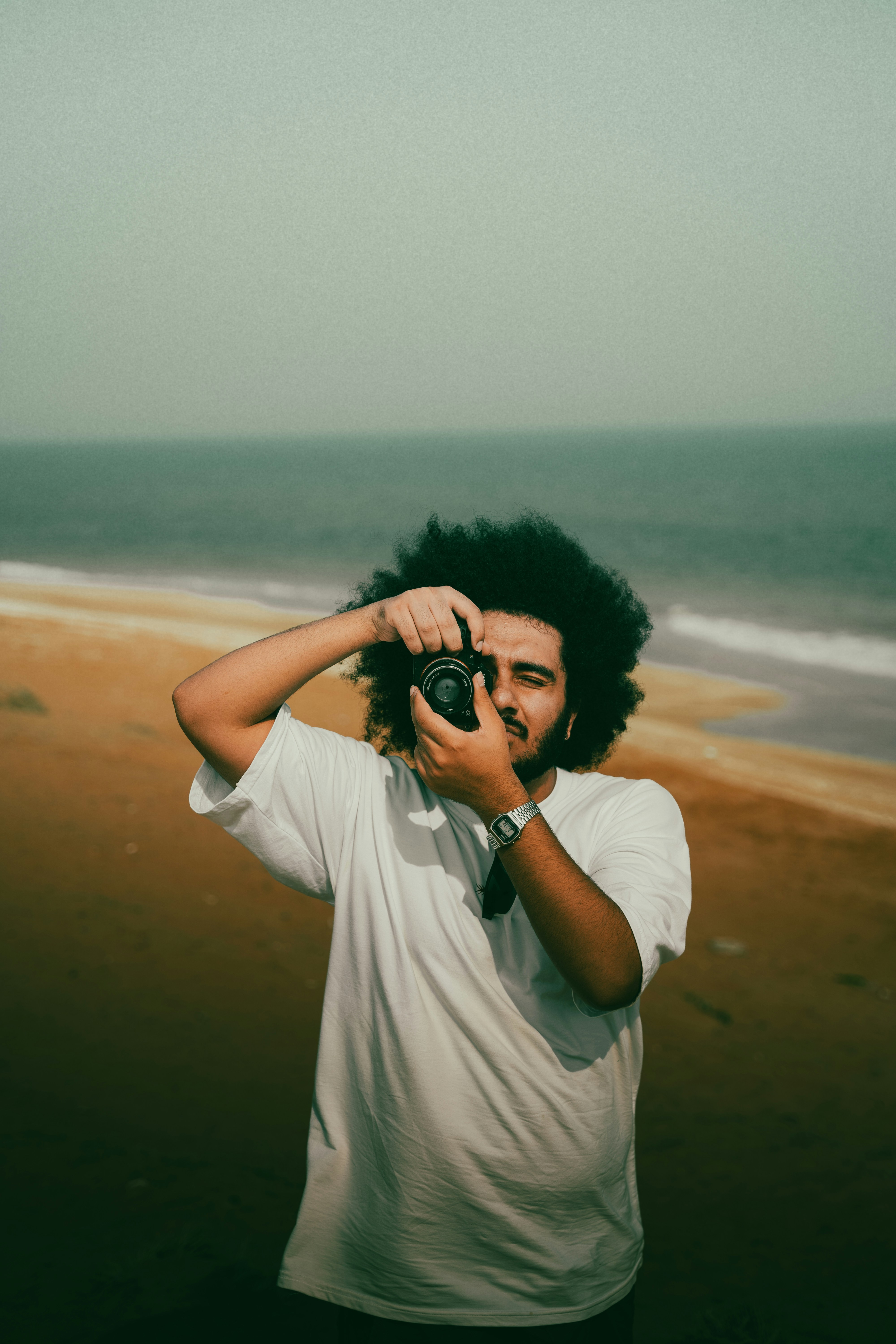 A photographer takes a photo near the ocean.