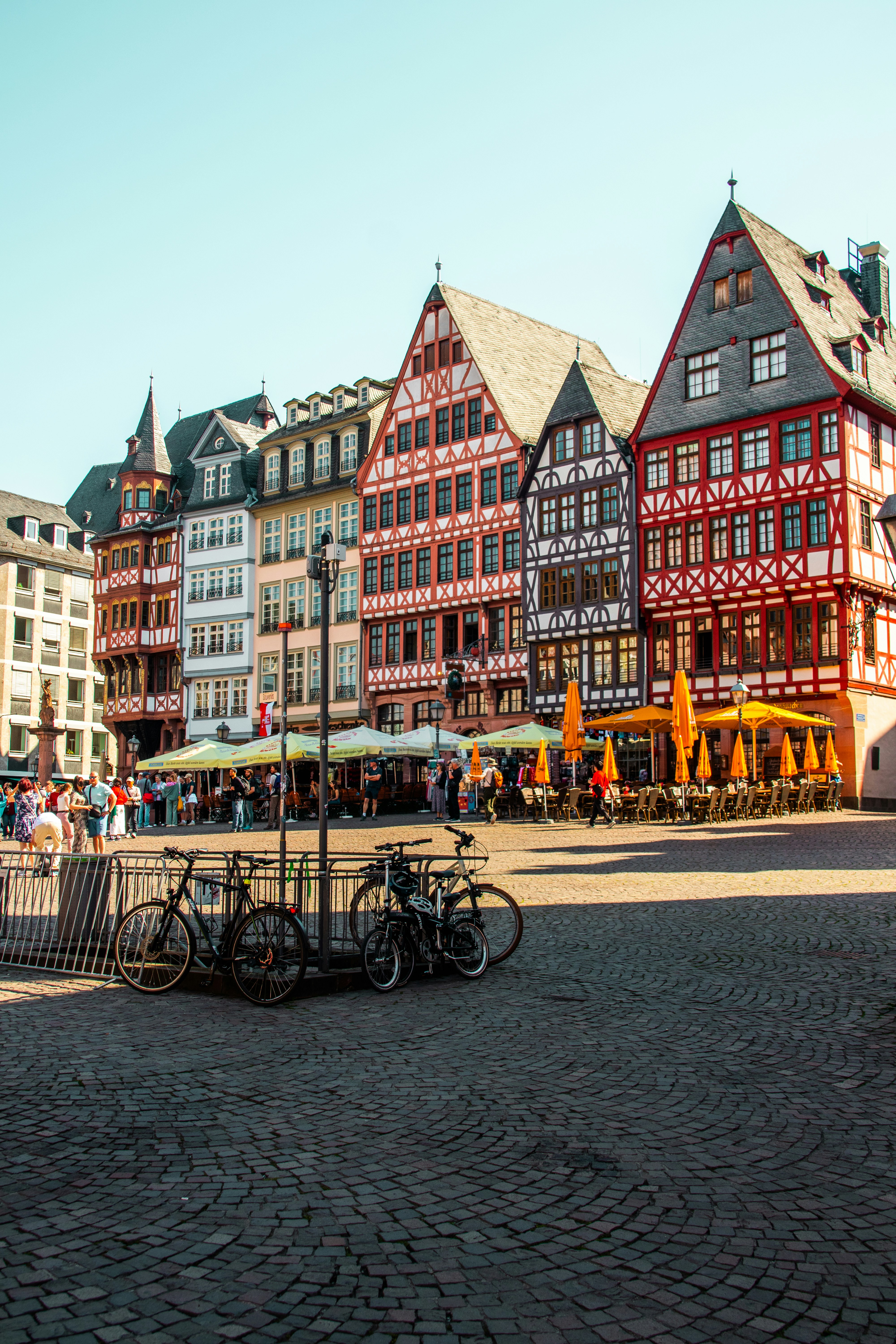 햇볕이 잘 드는 유럽 광장에 있는 다채로운 건물과 자전거. 사진 – Unsplash의 무료 도시 이미지, image size:3000x4500