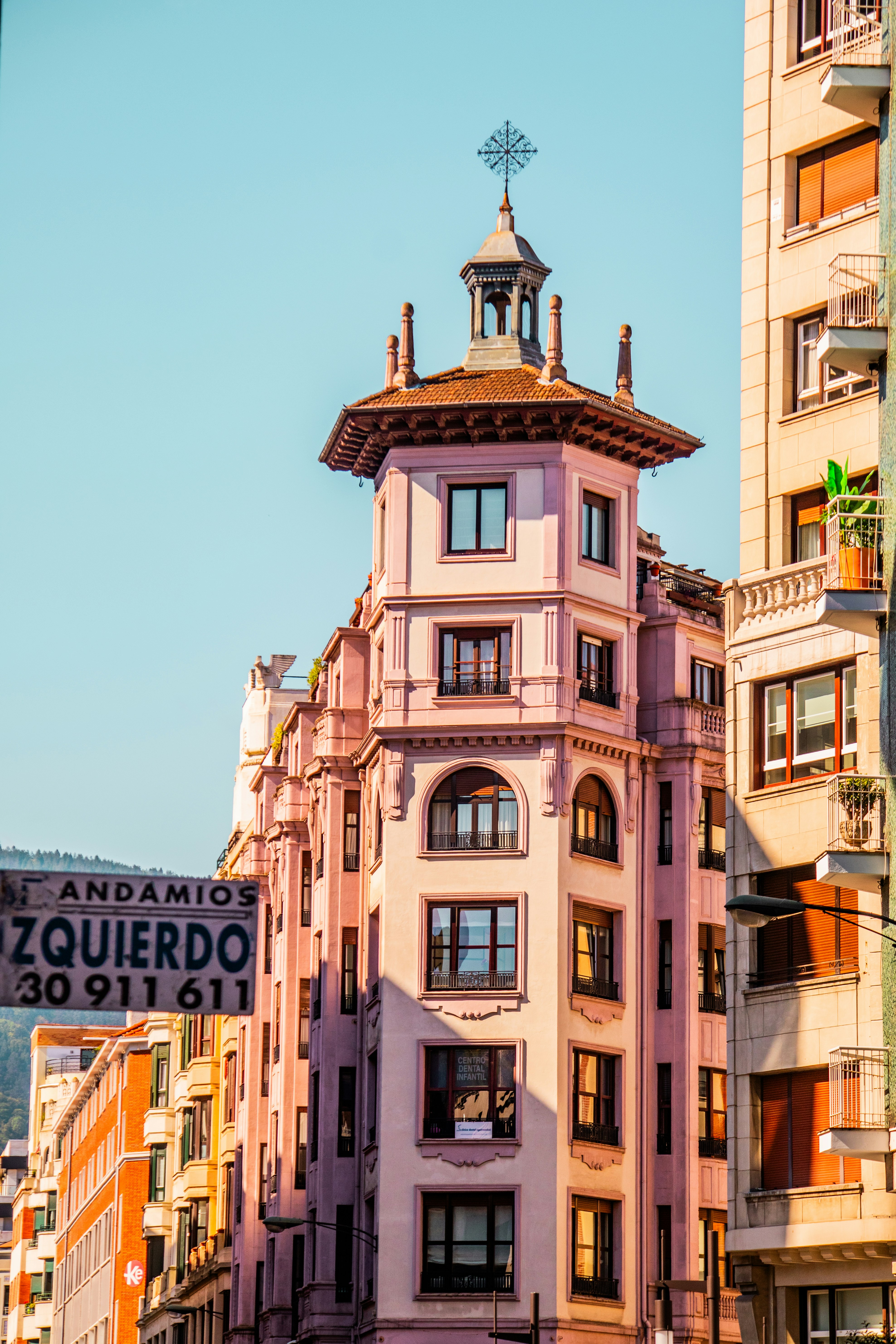 A pink building stands tall in an urban landscape.