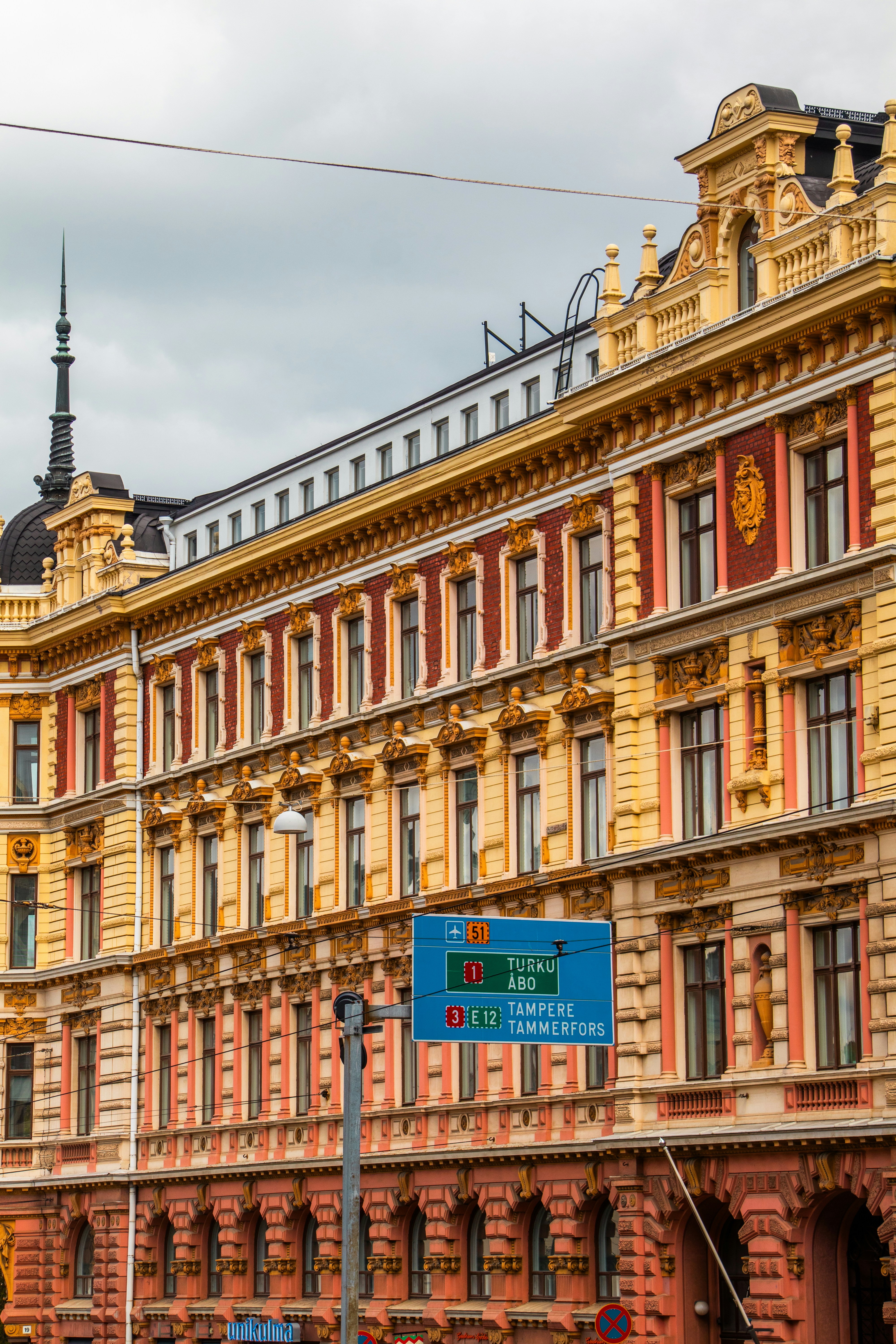 Ornate building with a blue road sign in front.