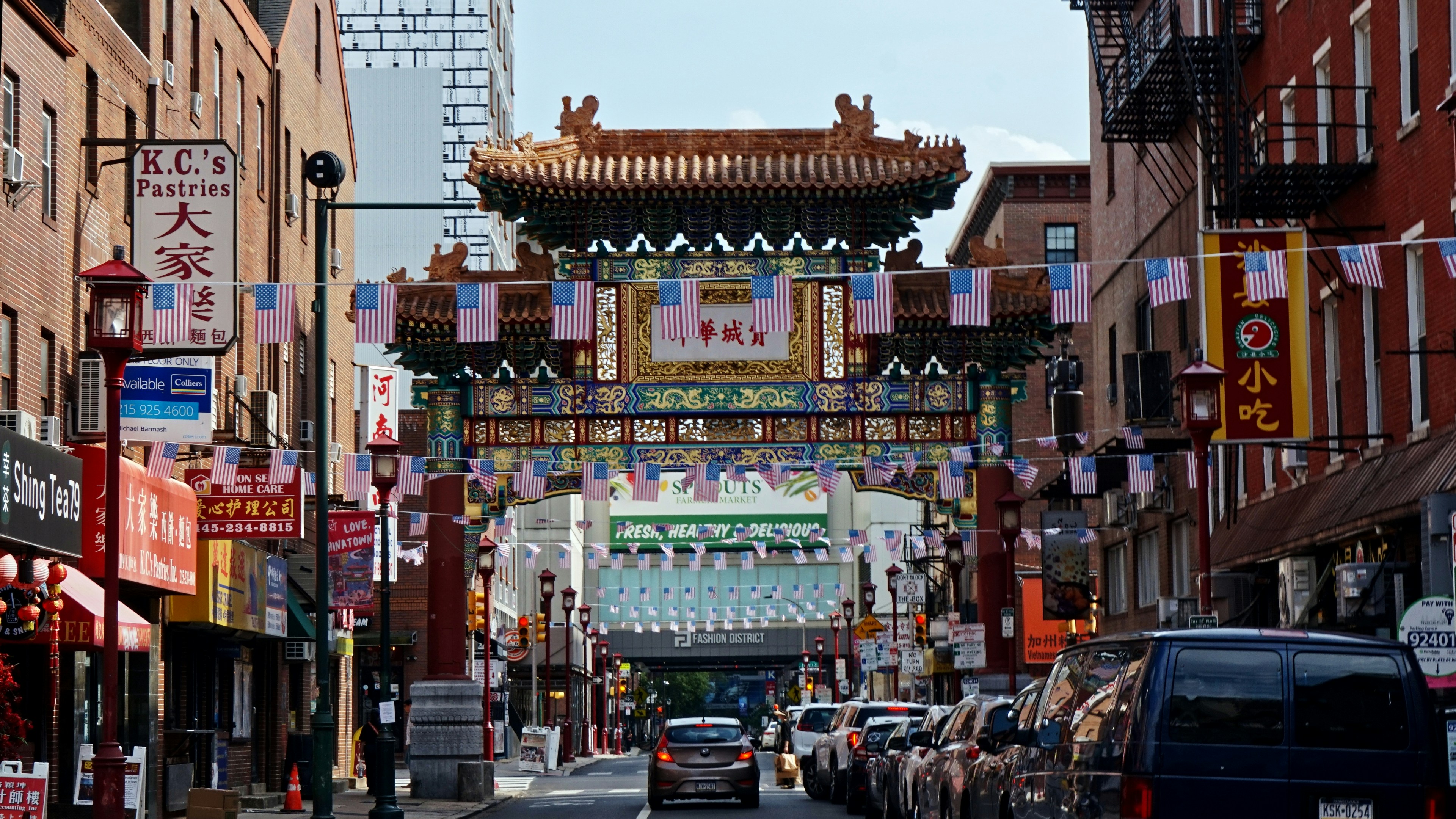 Chinatown's colorful gate framed by buildings and cars