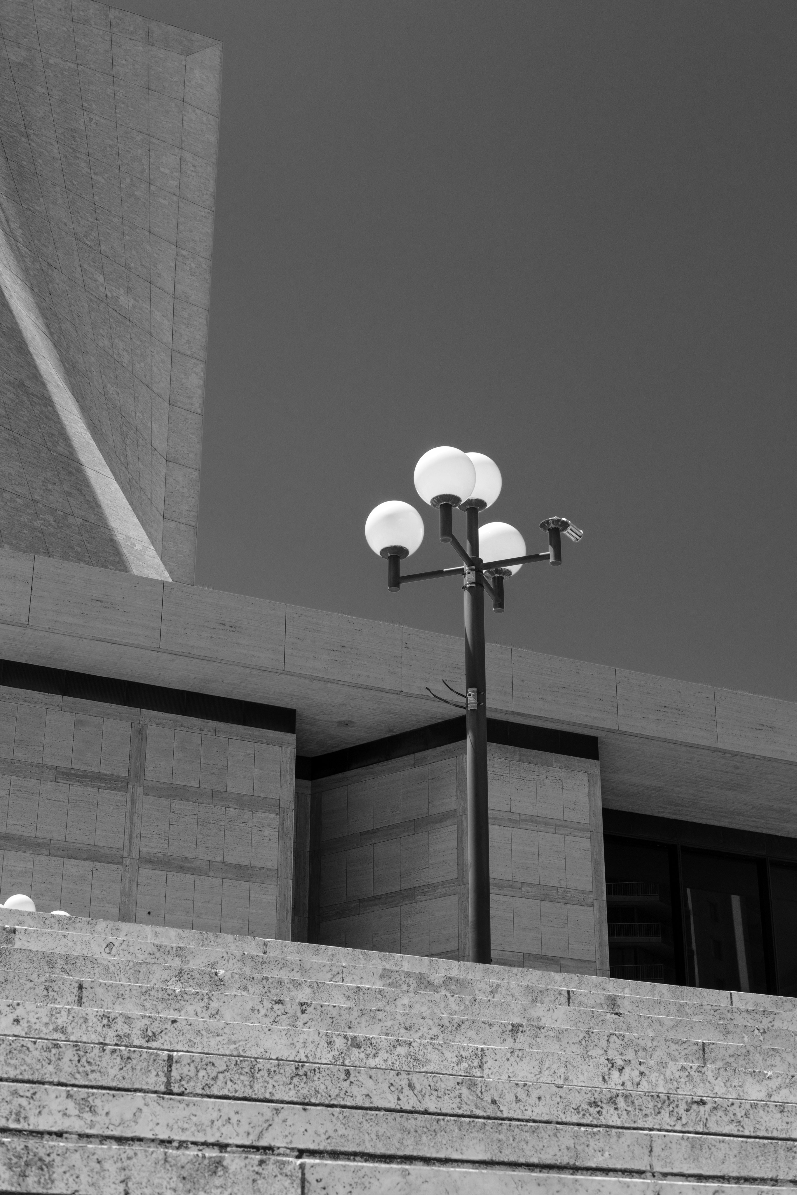 A street lamp stands in front of a building.