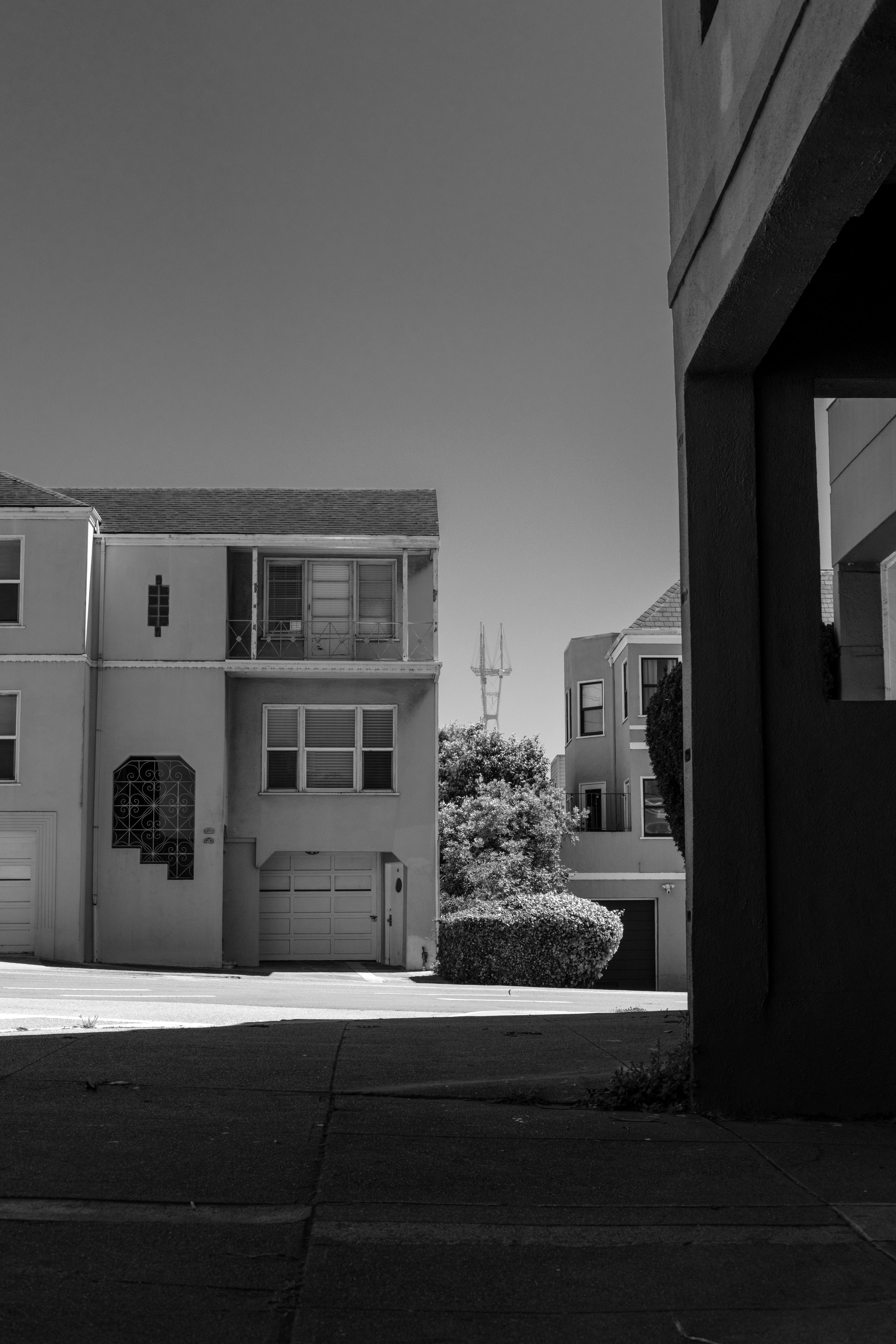 Neighborhood buildings with a distant tower in view.