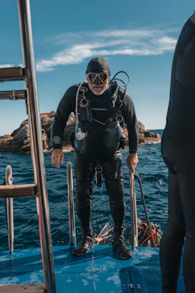 A scuba diver is climbing out of the water.