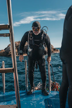 A scuba diver is climbing out of the water.