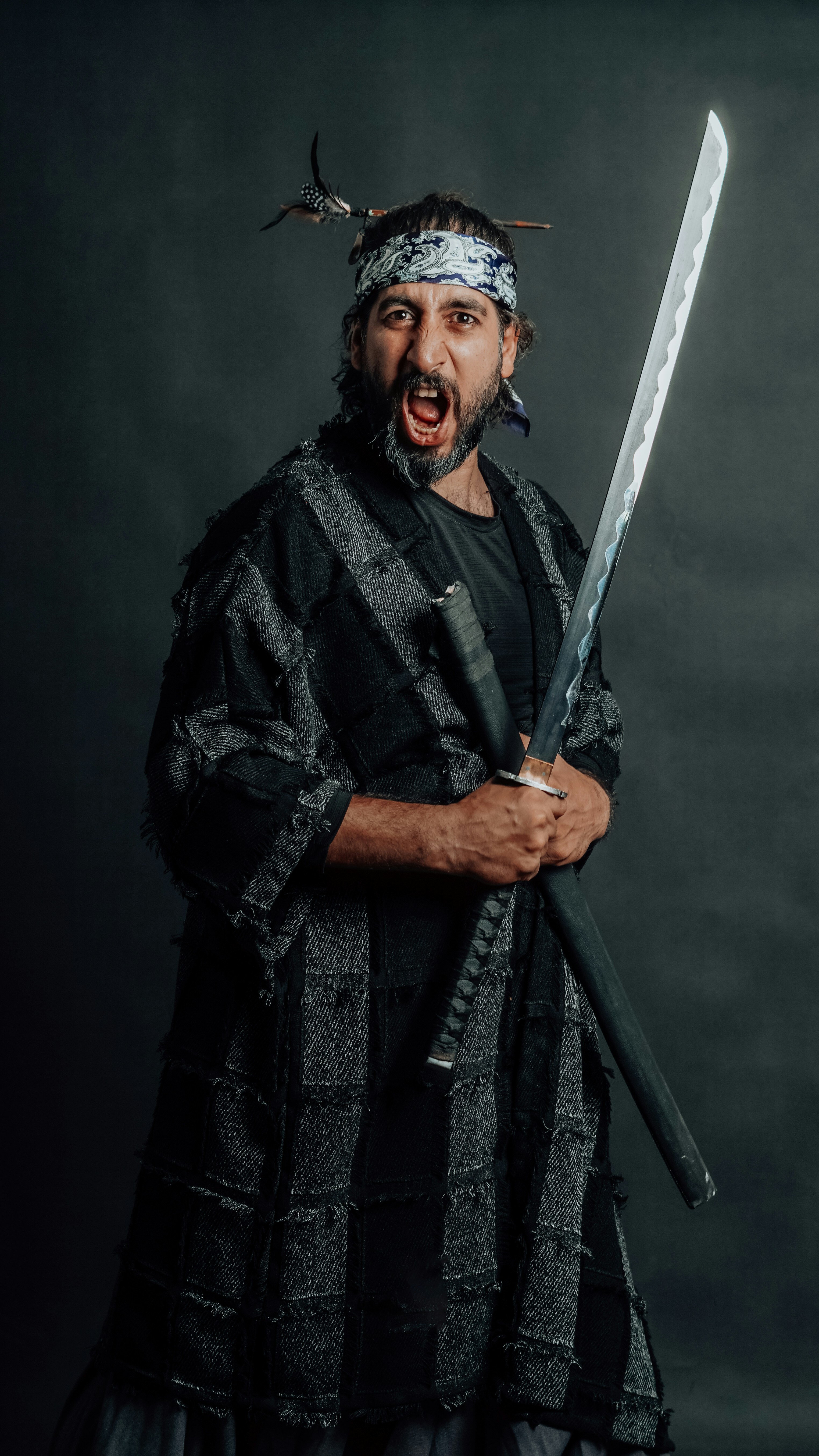 A samurai poses with sword and a fierce expression.