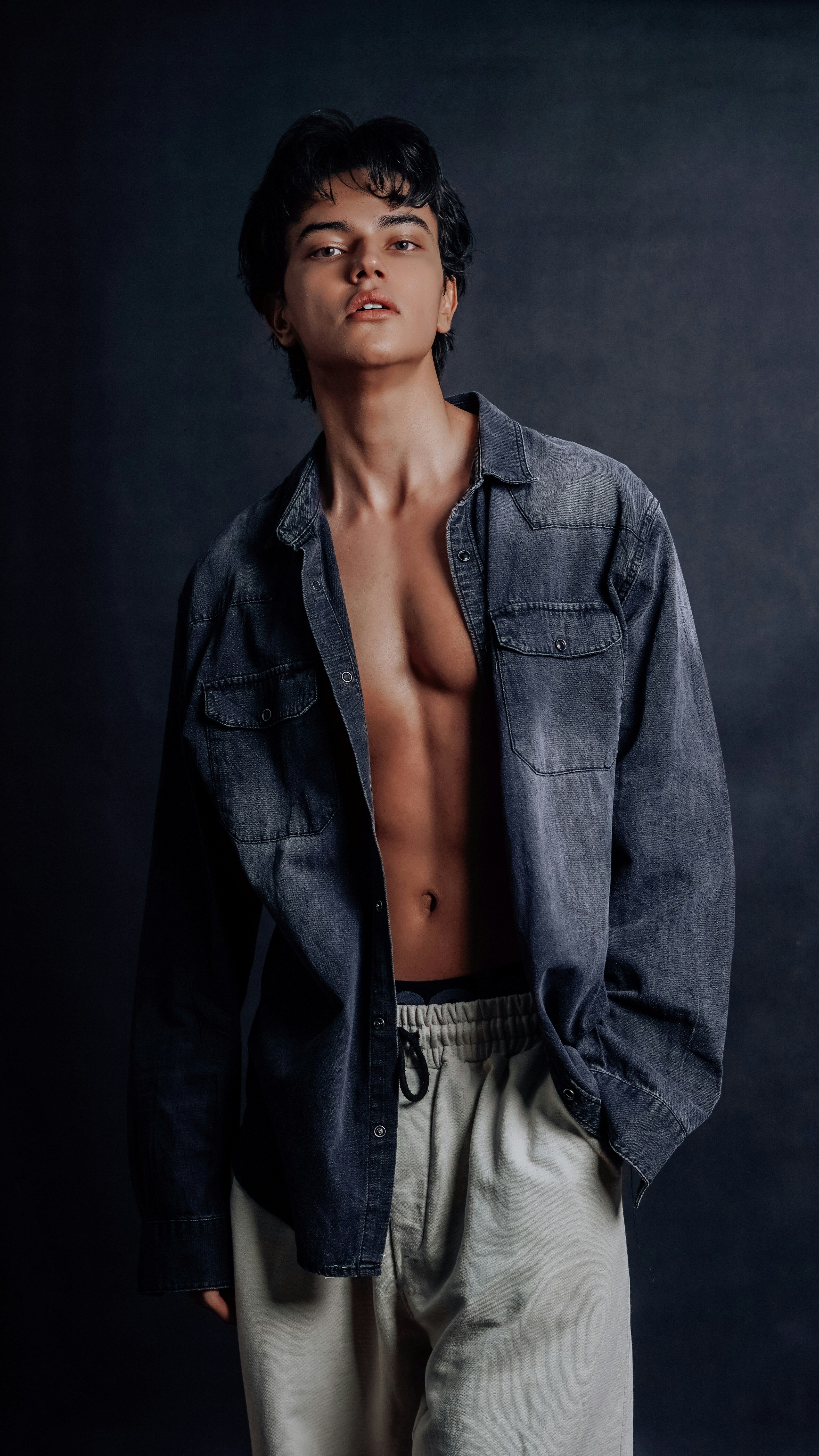 데님 셔츠를 입고 포즈를 취하는 잘생긴 남자. 사진 – Unsplash의 무료 어두운 배경 이미지