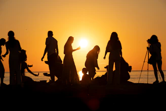 People are silhouetted against the stunning sunset.