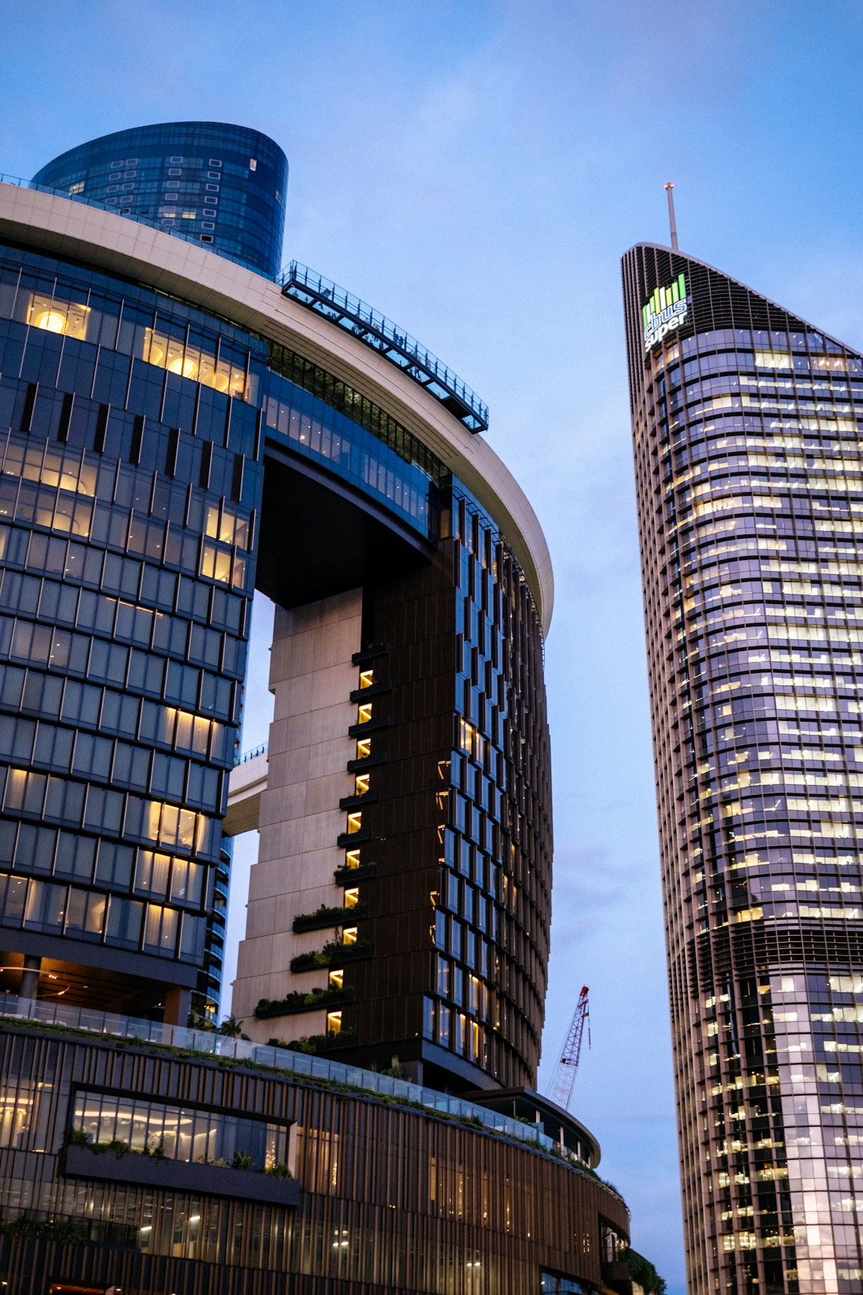 Modern skyscrapers illuminated against a blue sky.