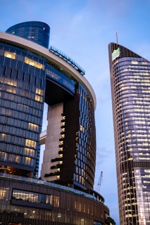 Modern skyscrapers illuminated against a blue sky.