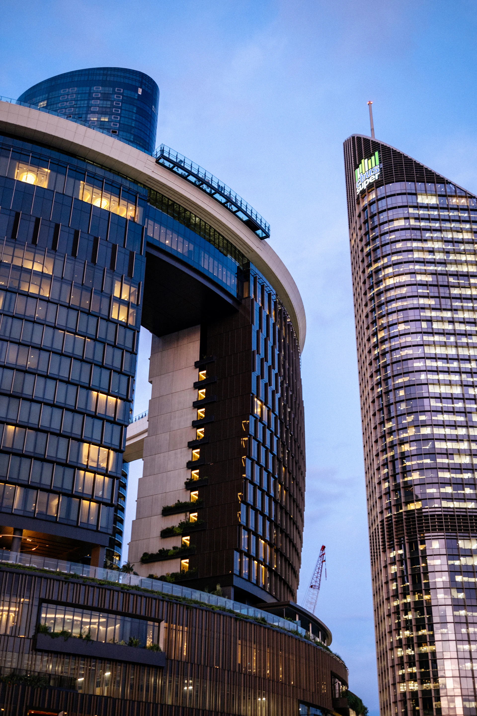 Modern skyscrapers illuminated against a blue sky.