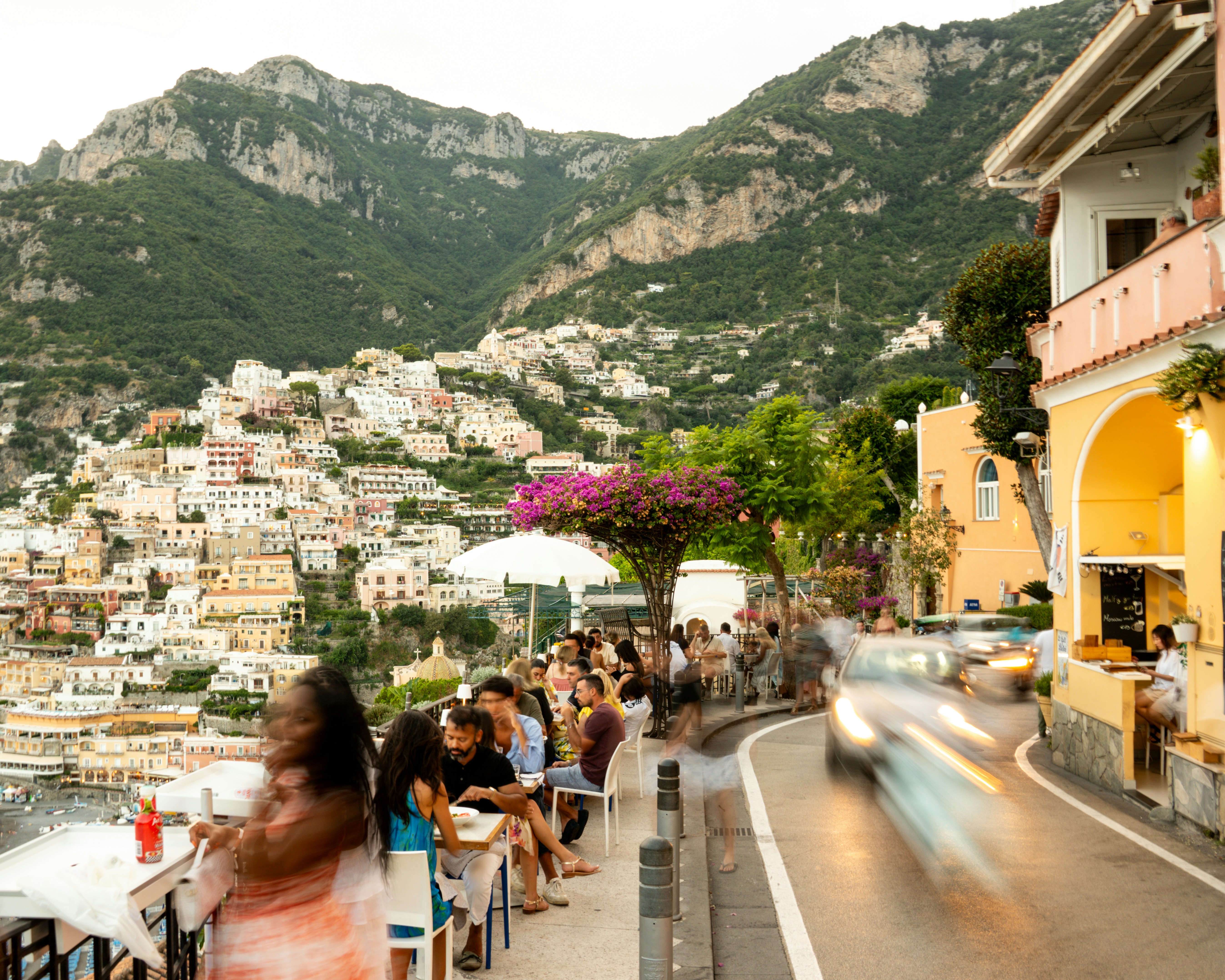 People dine at a restaurant overlooking a coastal town.