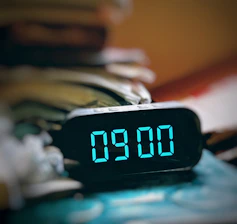 The time is nine o'clock, displayed on a clock