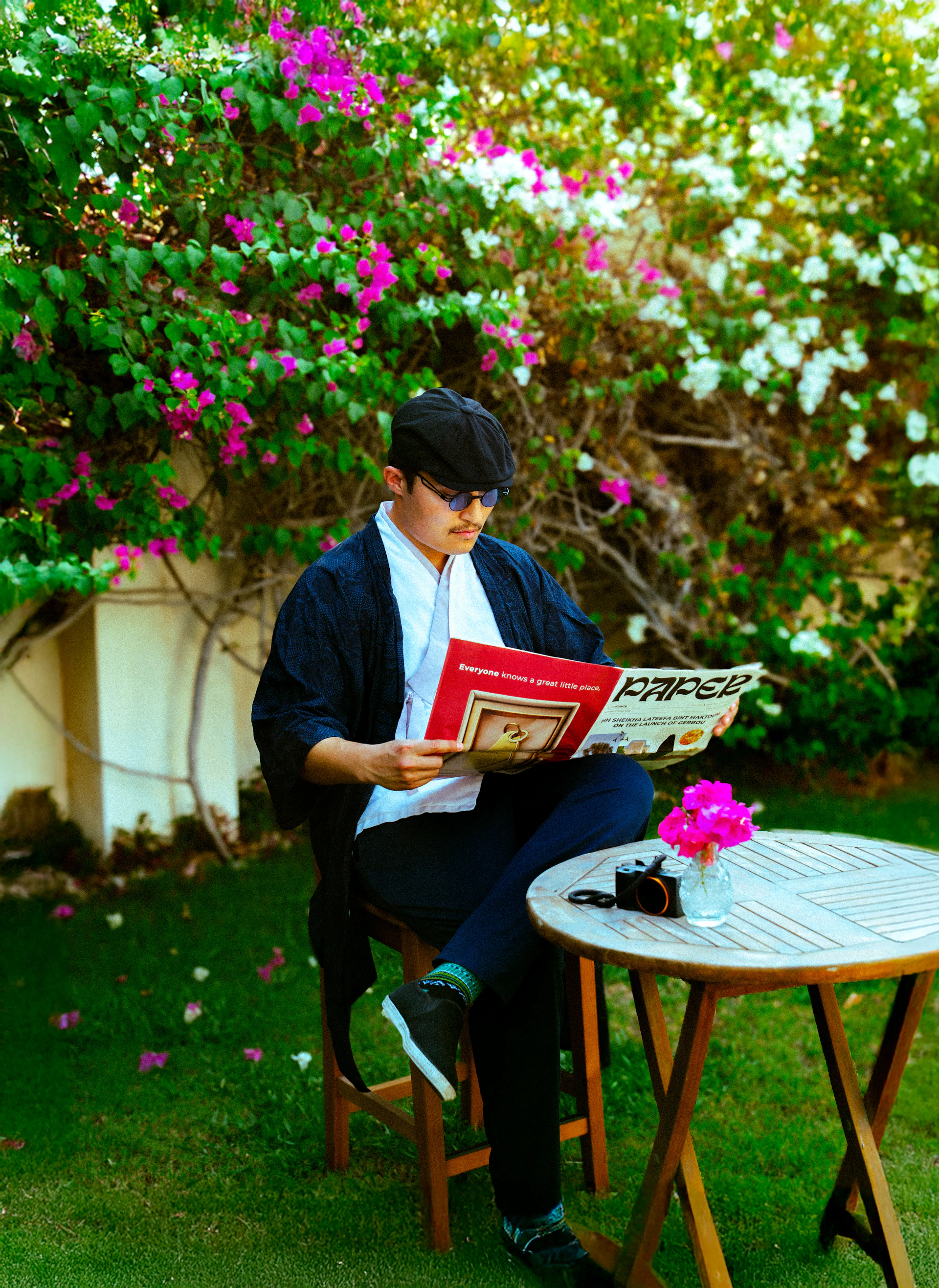 Man reads a newspaper in a beautiful garden.
