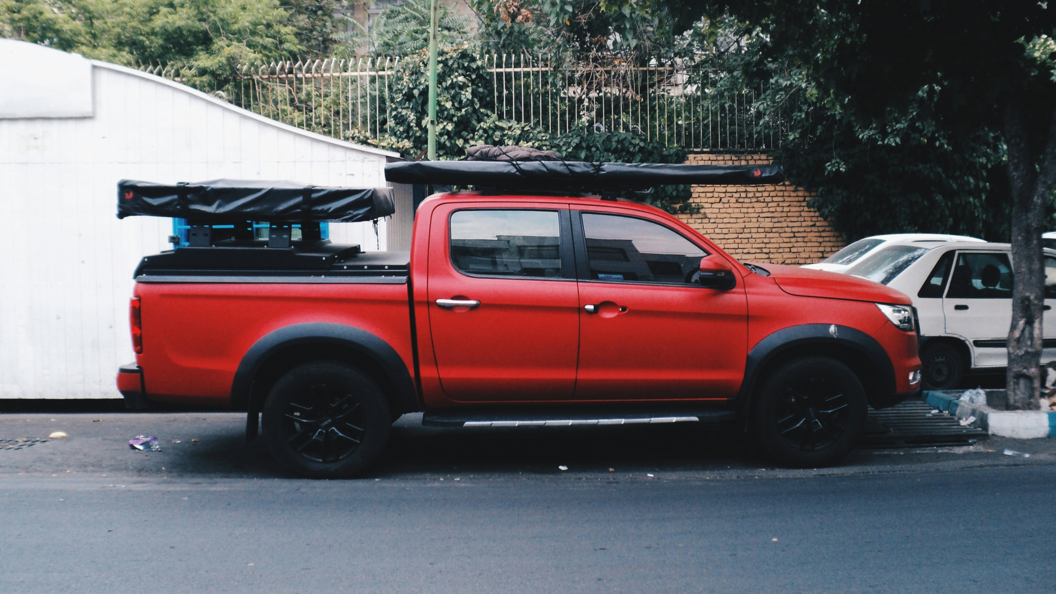 Une camionnette rouge est garée dans la rue.