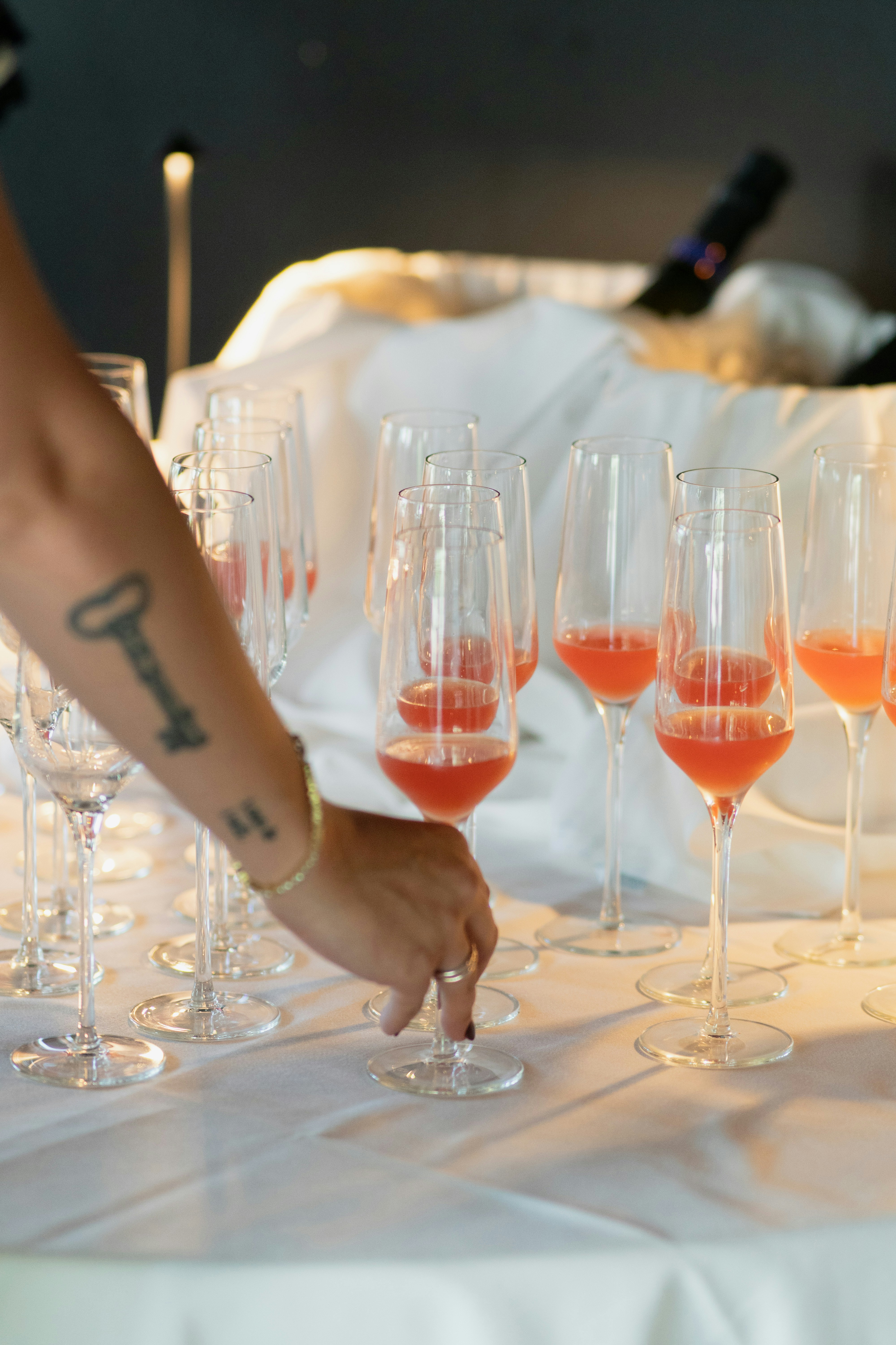 Someone is selecting a glass of pink beverage.