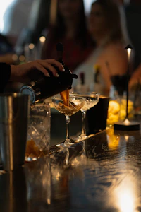 Bartender pouring drinks into champagne glasses