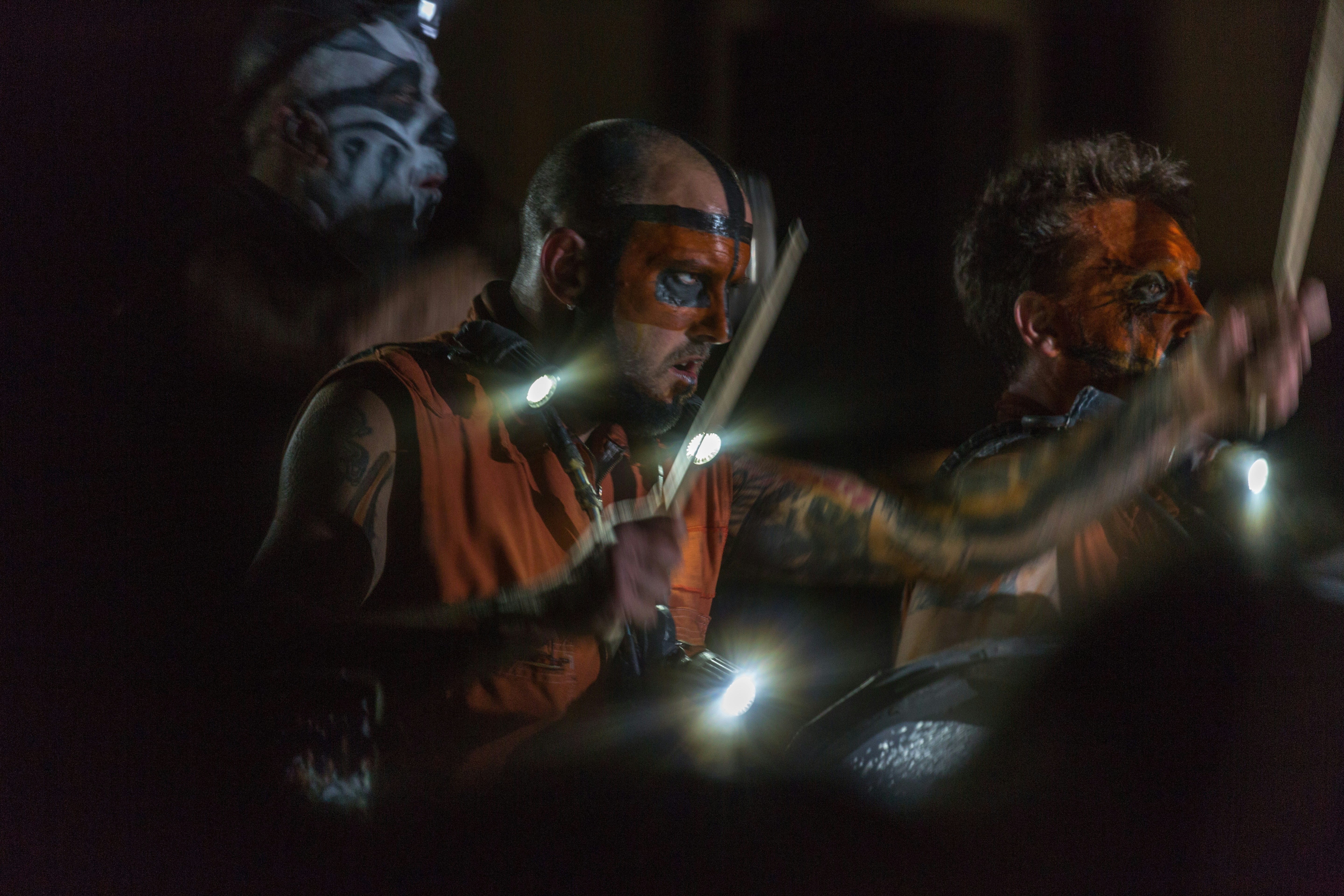 Drummers perform in the darkness with glowing sticks