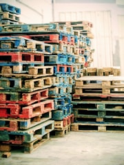 A large stack of colorful wooden pallets.