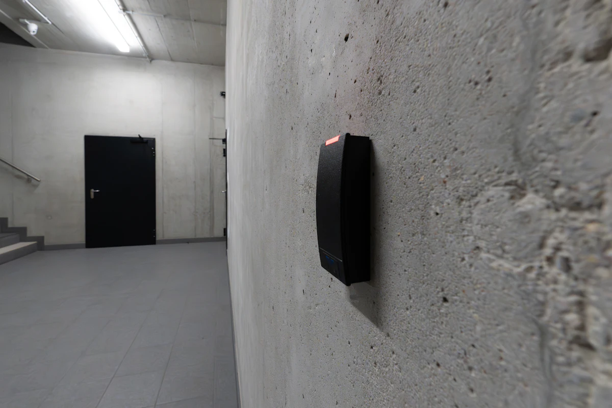 Lector de tarjetas NFC para control de accesos en la pared, junto a una puerta