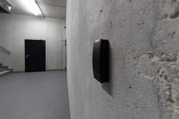 Card reader on a concrete wall beside a secure door