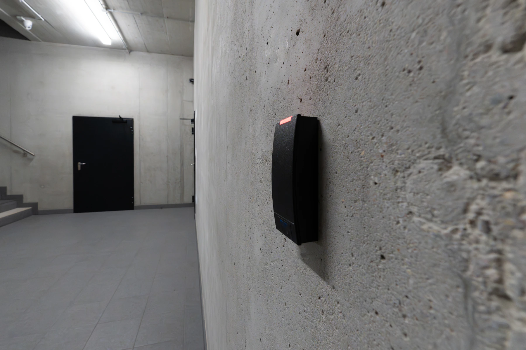 Modern electronic access control card reader beside a secured door