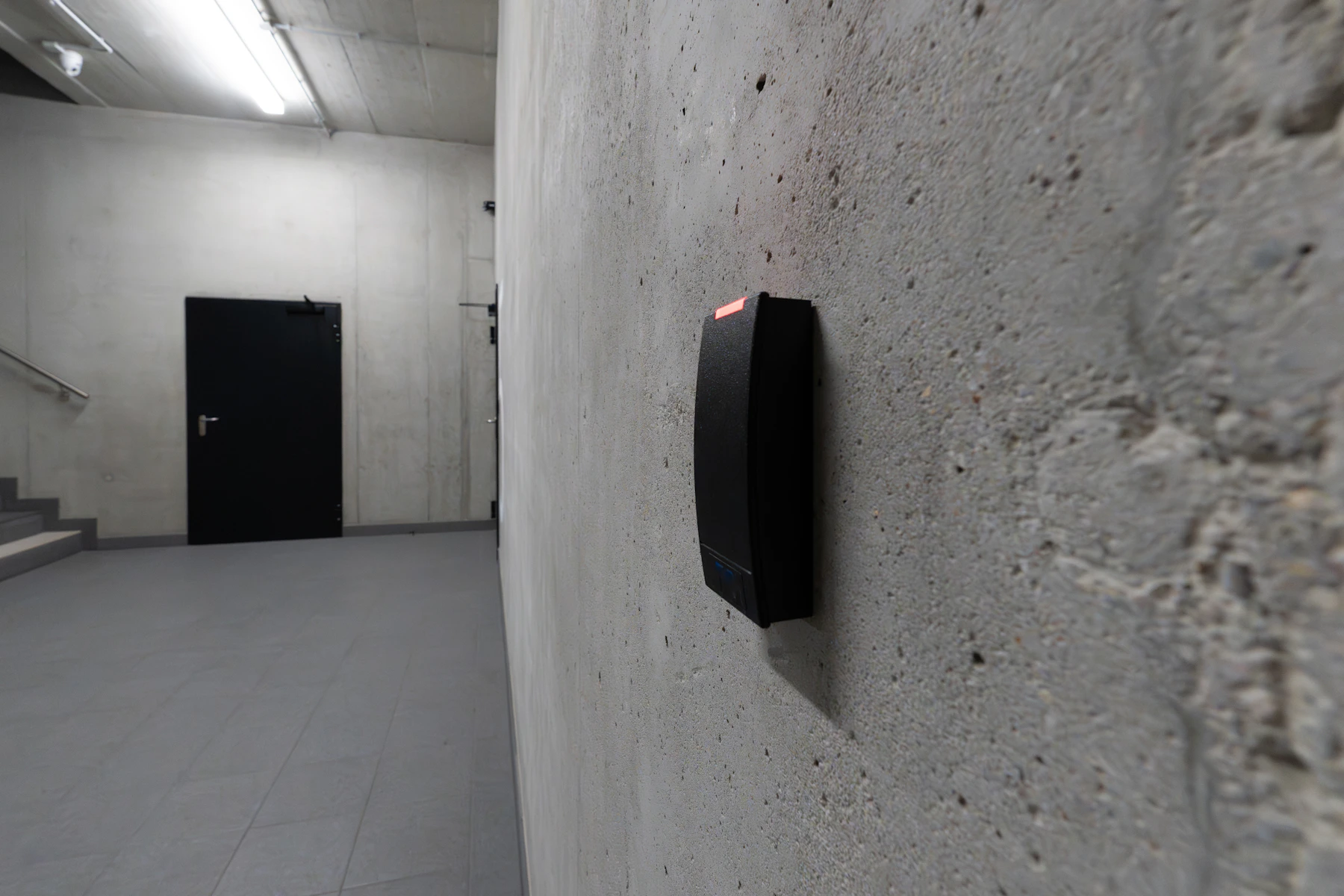 Modern electronic access control card reader beside a secured door
