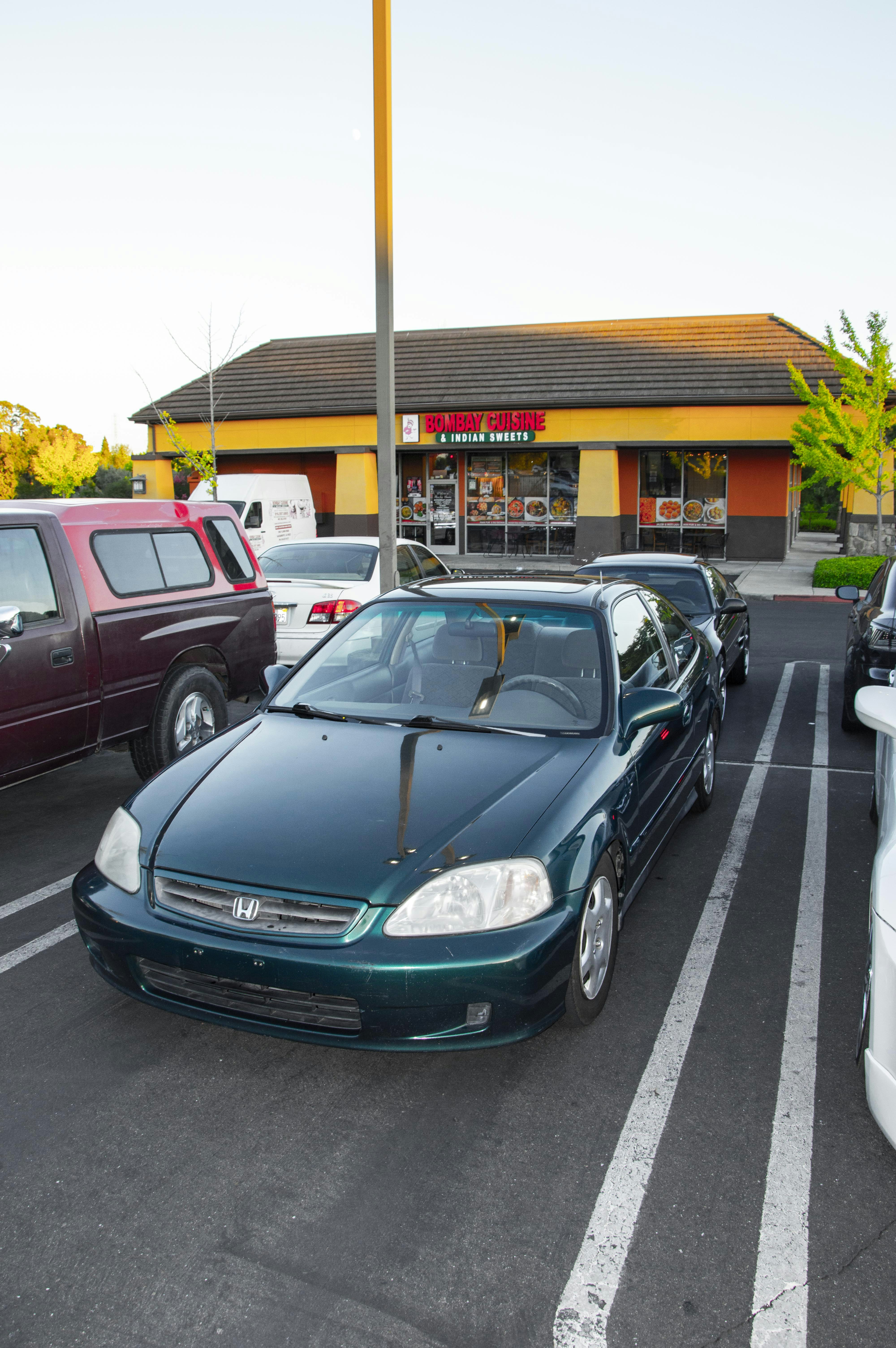 Une Honda Civic verte garée dans un parking.