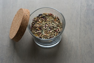 Dried herbs in a glass jar.