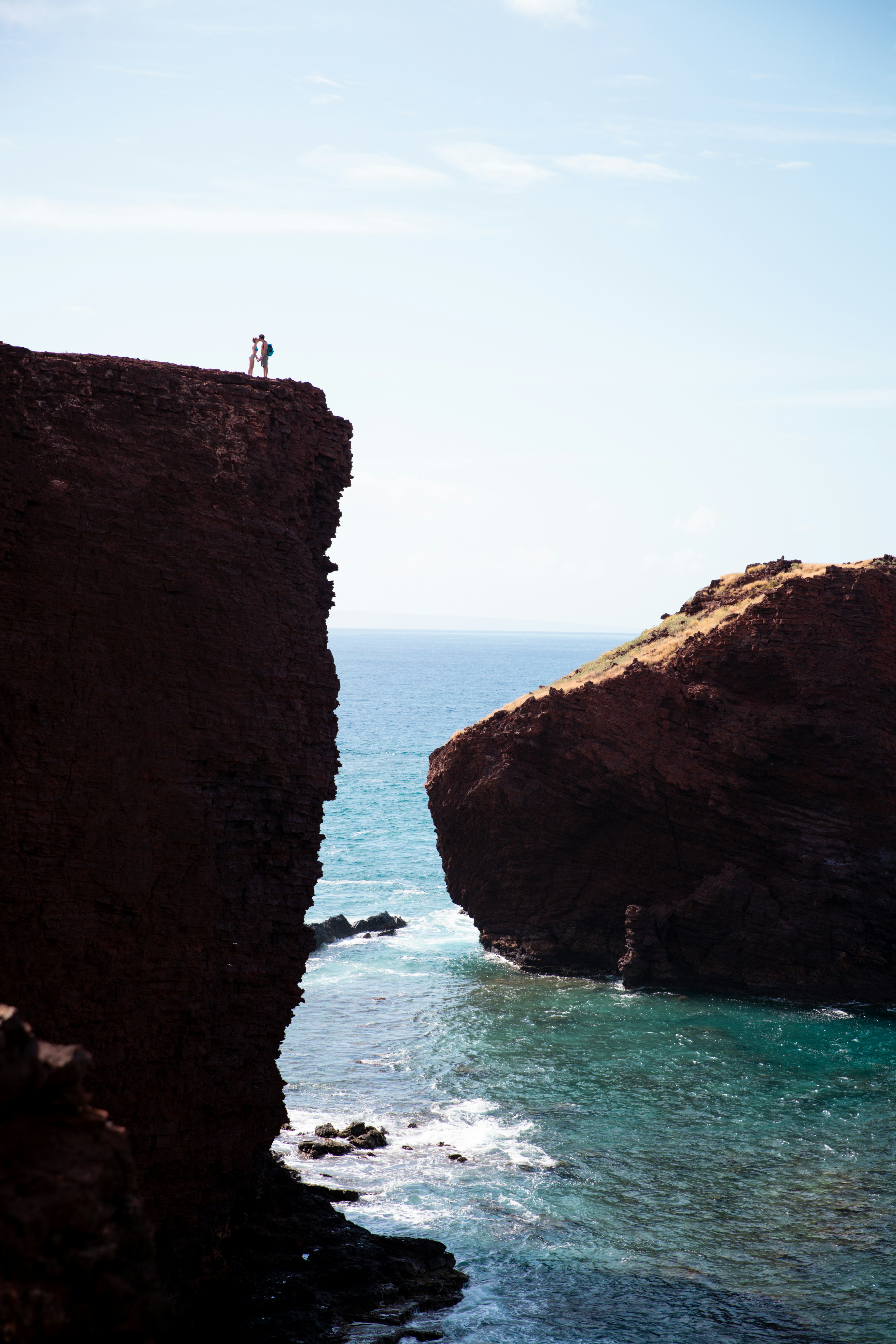 Couple standing on a cliff overlooking the ocean