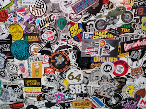 A wall is covered with many different stickers
