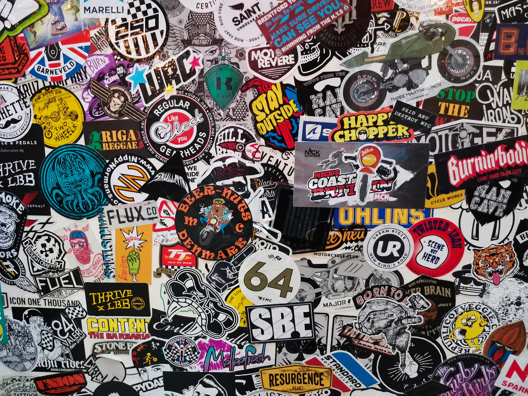 A surface layered with round and die-cut brand and club logo stickers