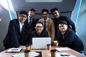 A team of professionals is gathered around a table.