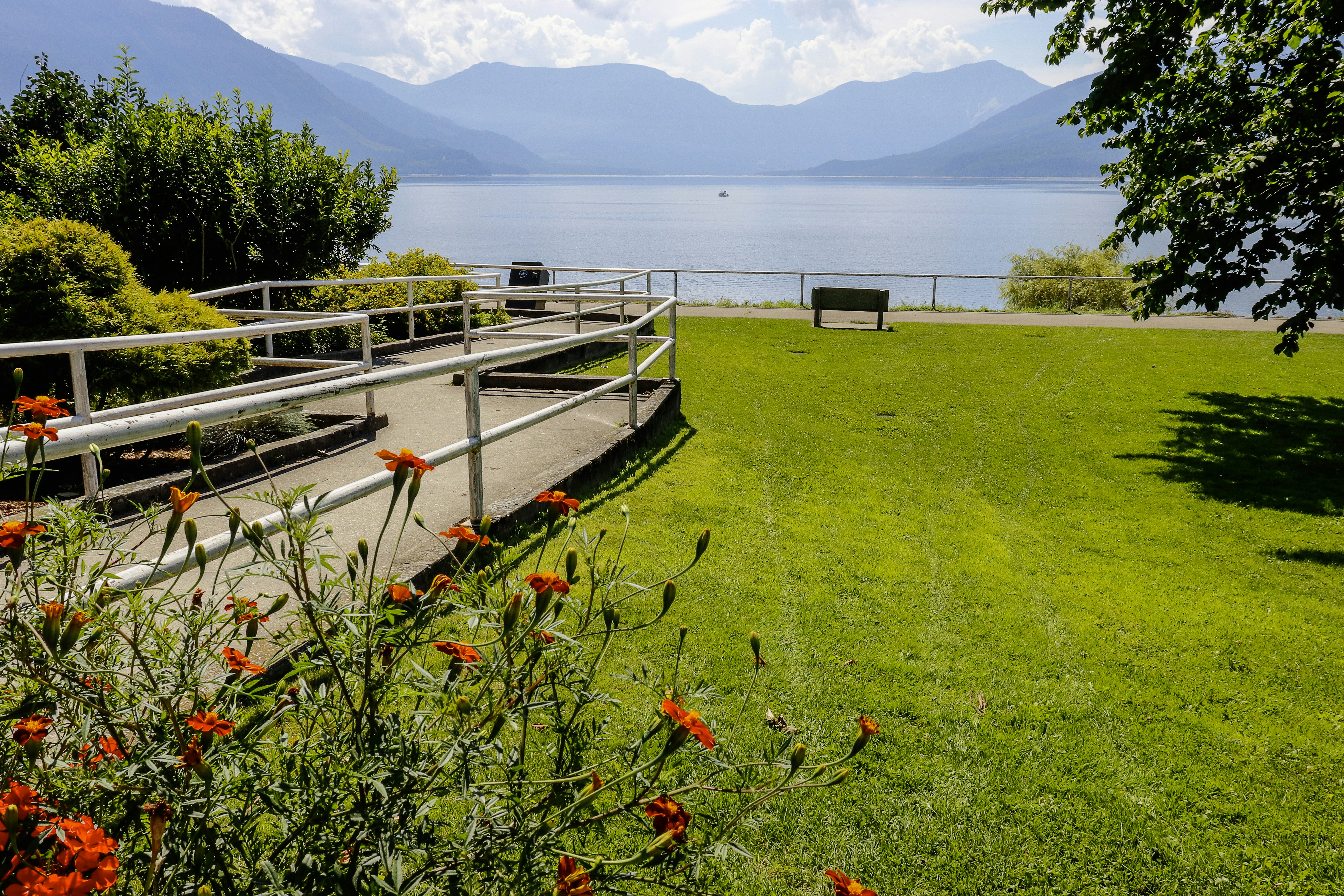 A scenic park overlooks a beautiful lake and mountains.