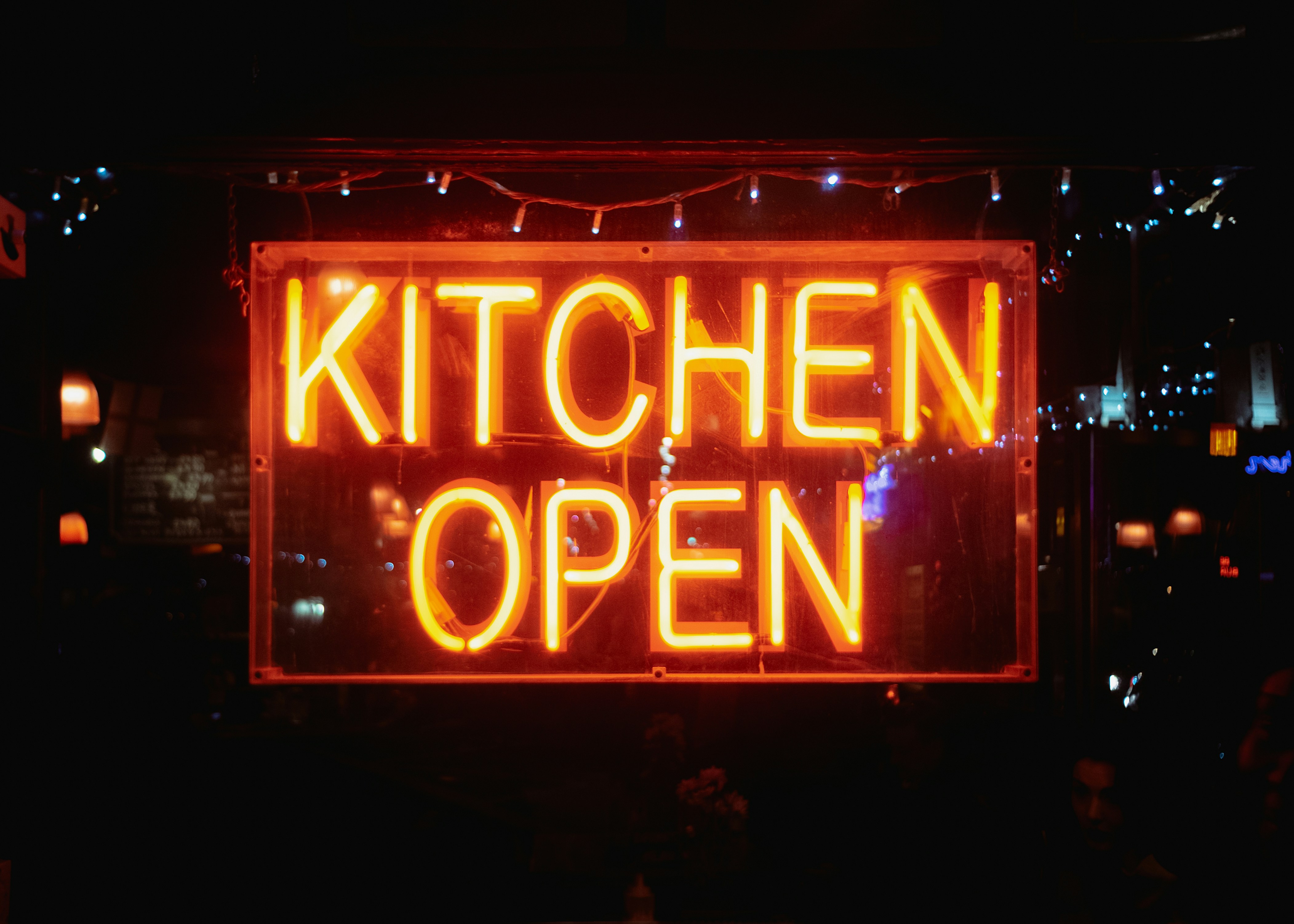 The kitchen is open, illuminated by neon.