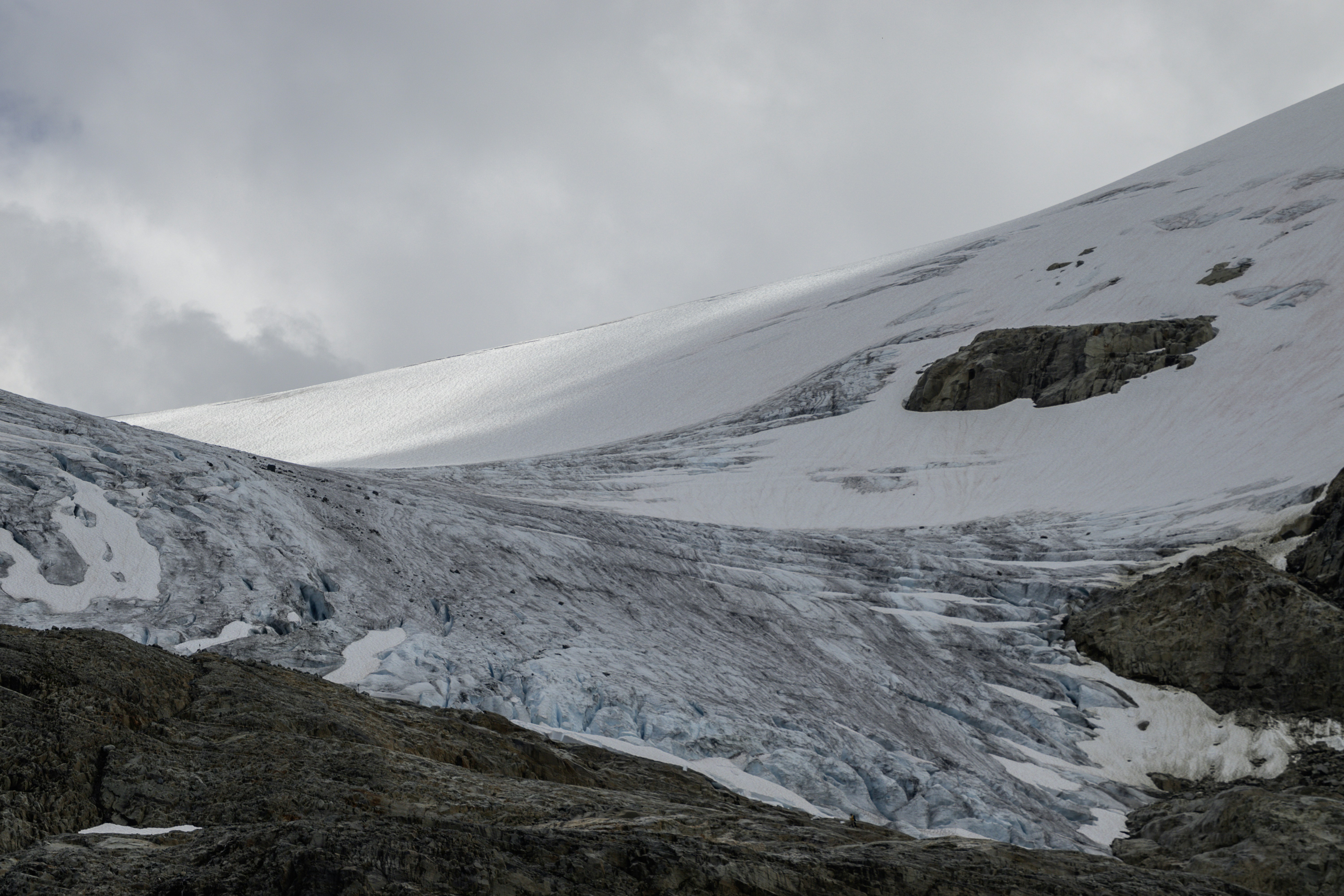 A glacier slowly slides down a mountain.