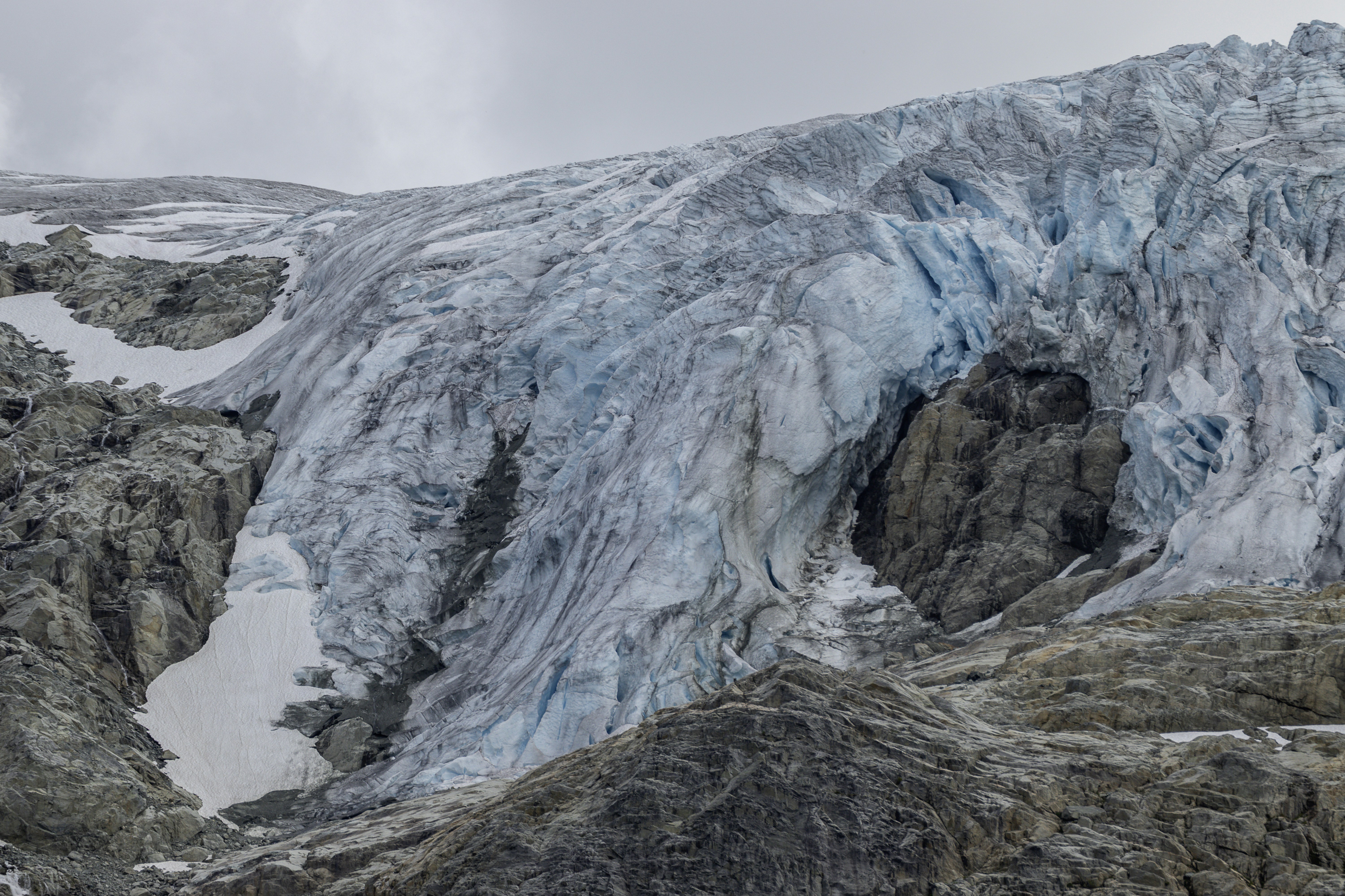 A glacier descends down rocky terrain.