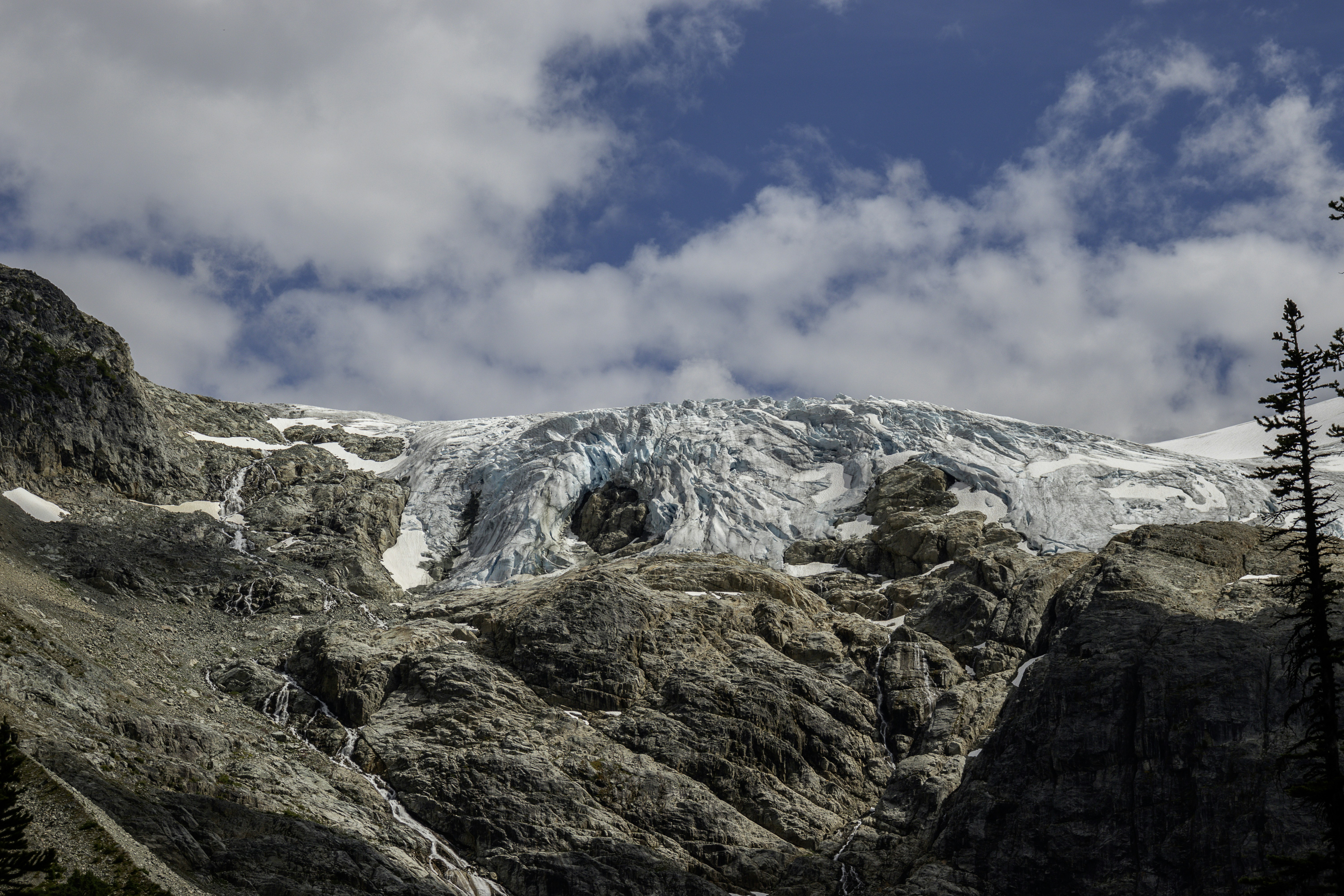 A majestic glacier under a cloudy blue sky.