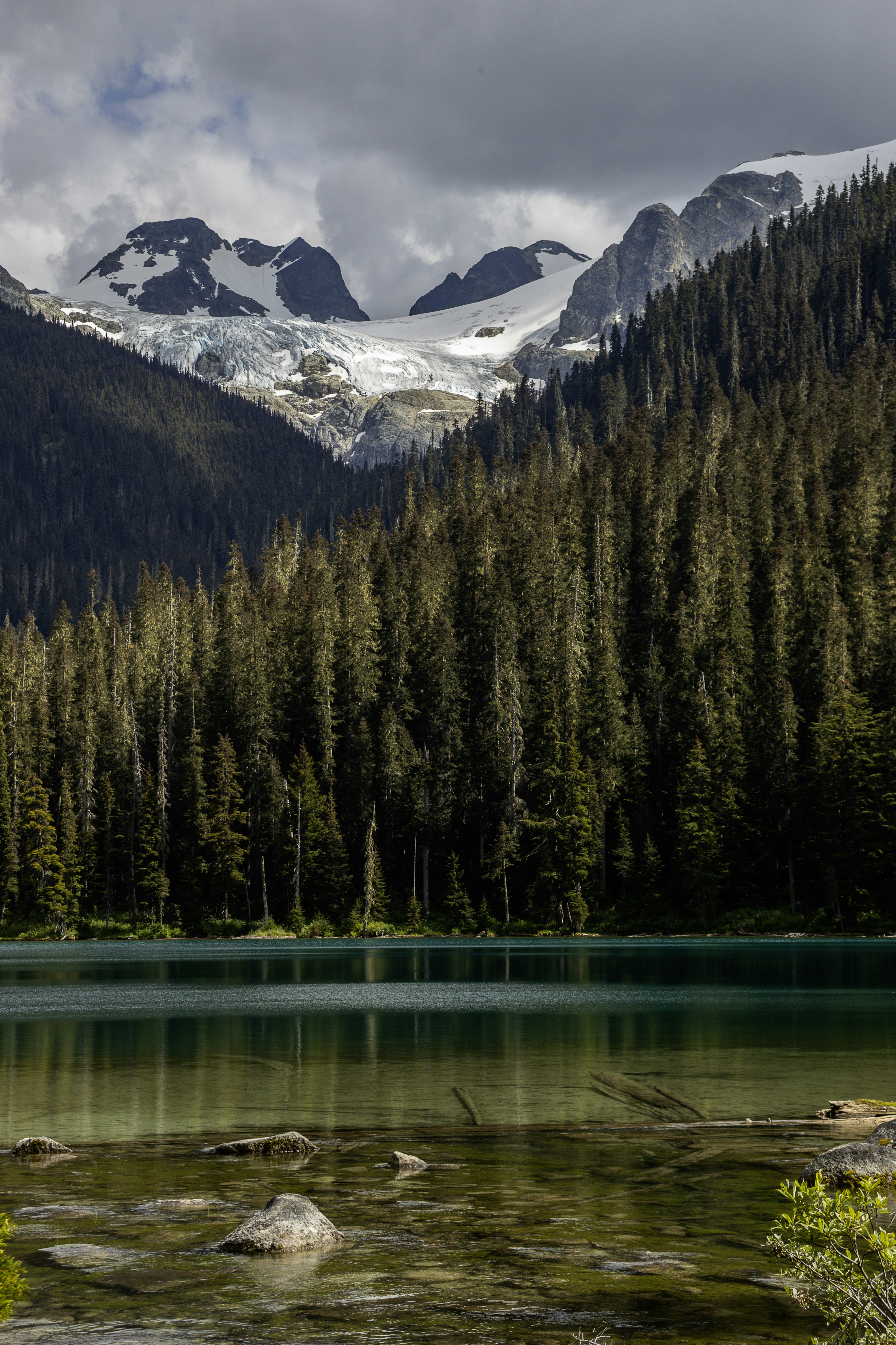 Mountain with a glacier overlooking a turquoise lake.