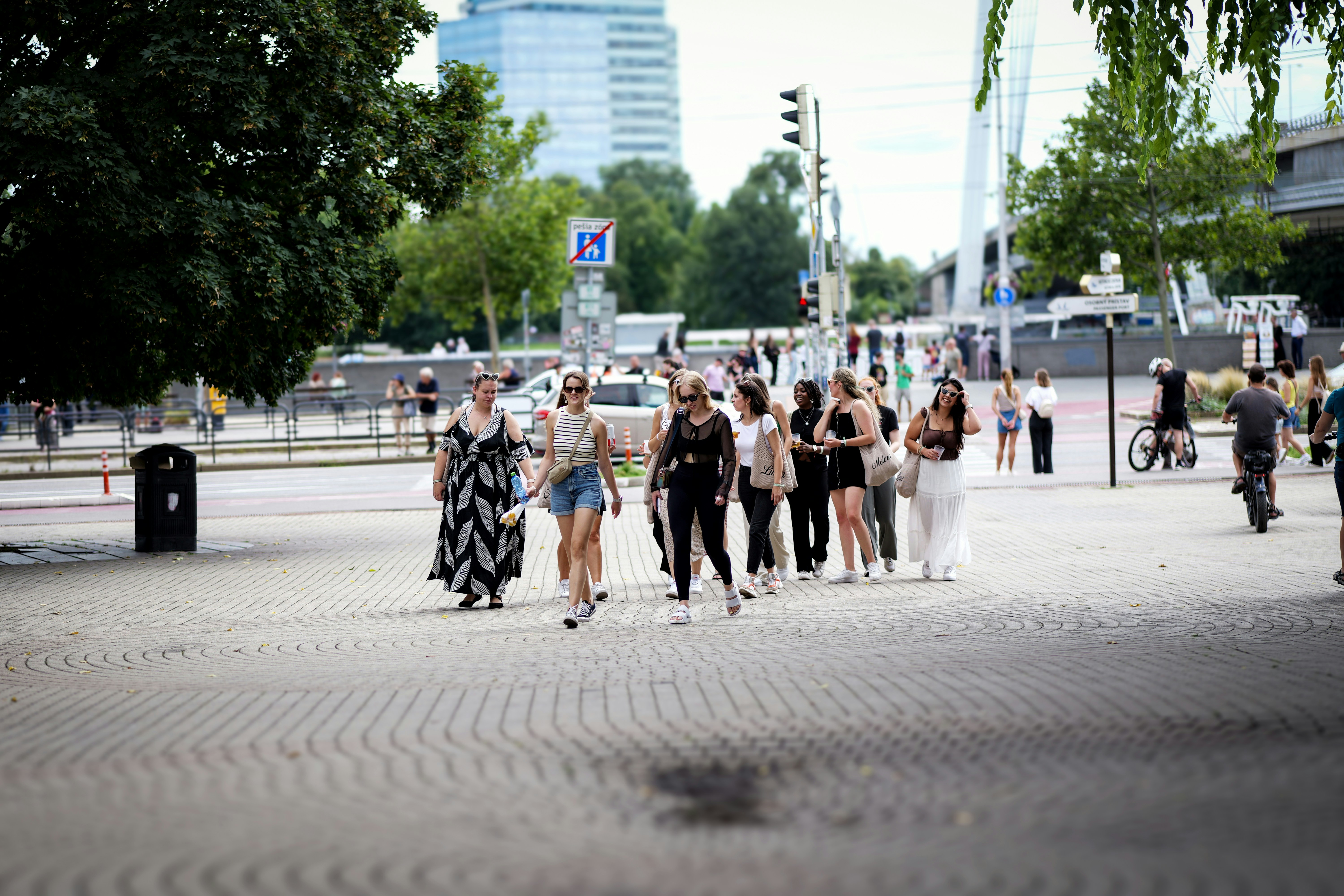 Um grupo de pessoas caminha em uma estrada pavimentada.