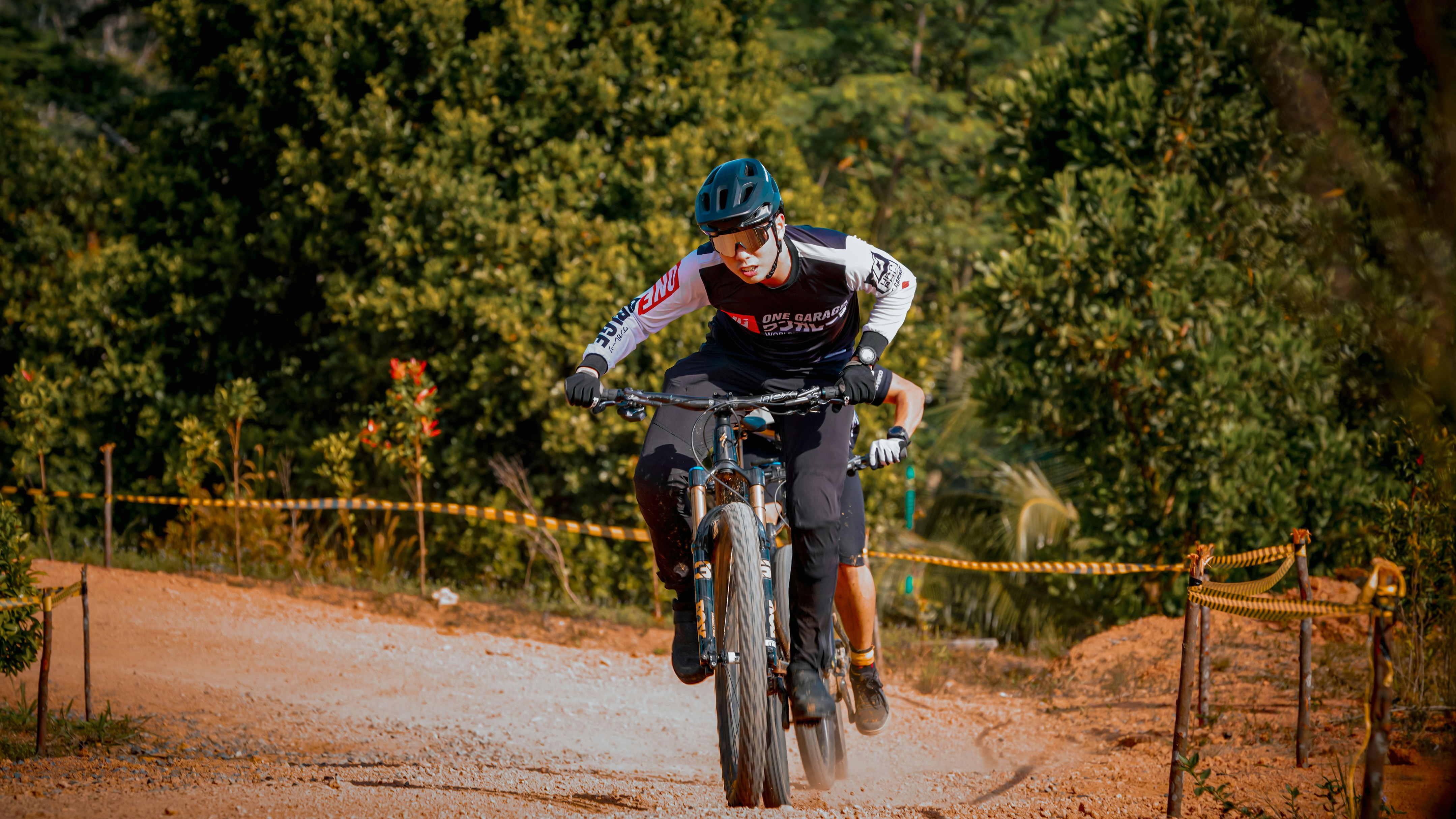 A mountain biker rides down a dusty trail.