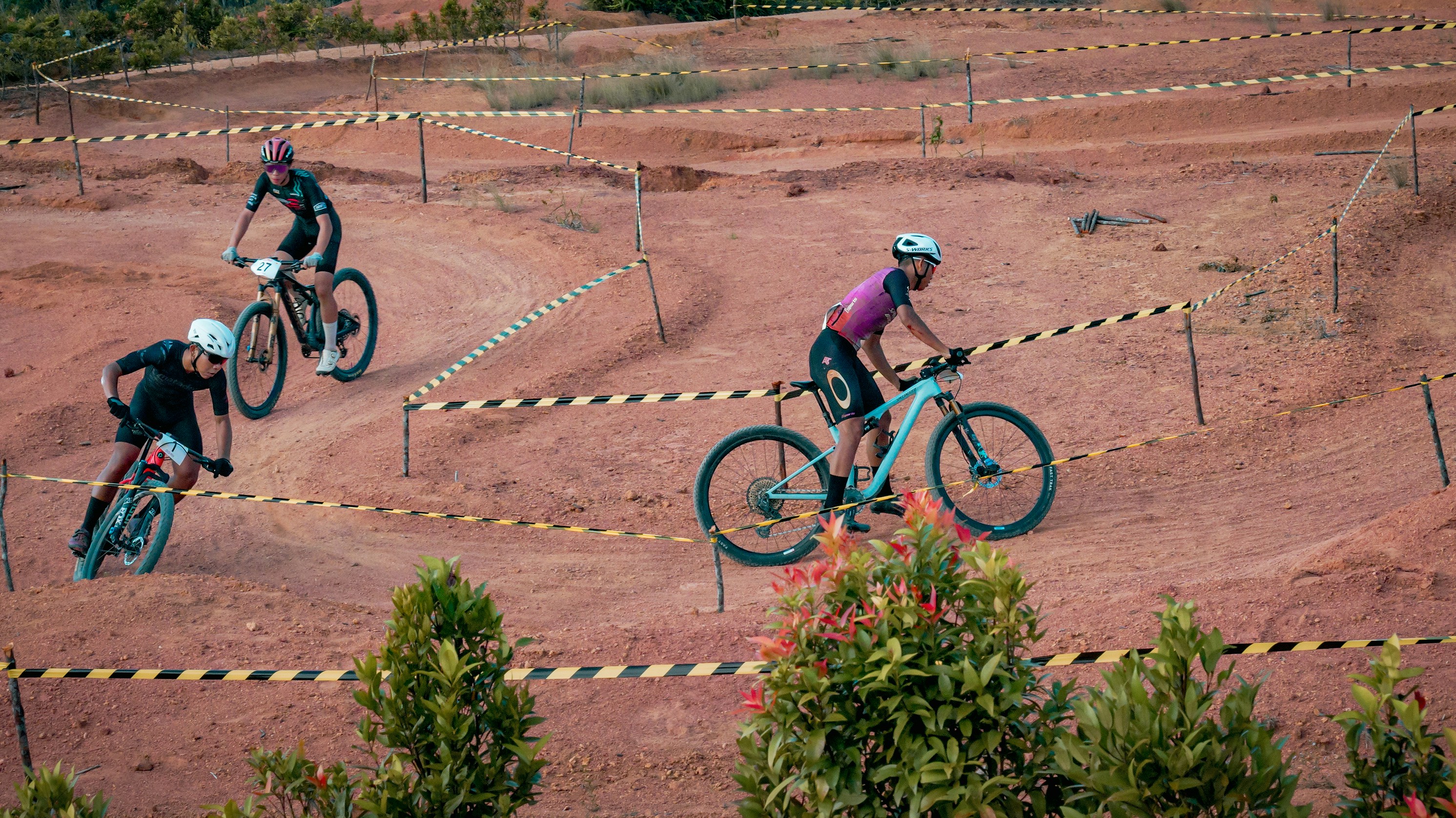 Cyclists race on a dirt bike course.
