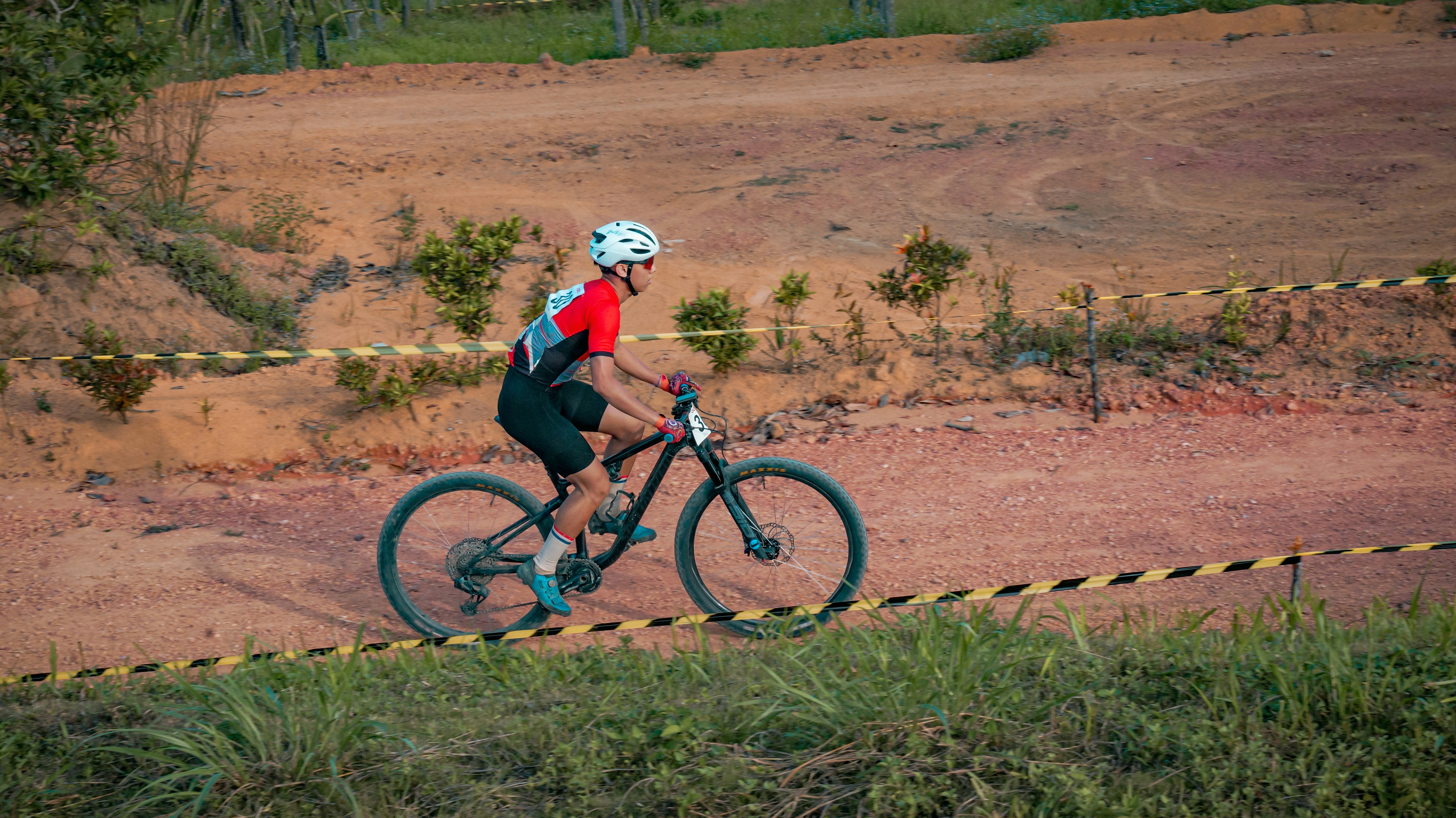 Cyclist rides a mountain bike on a dirt track.