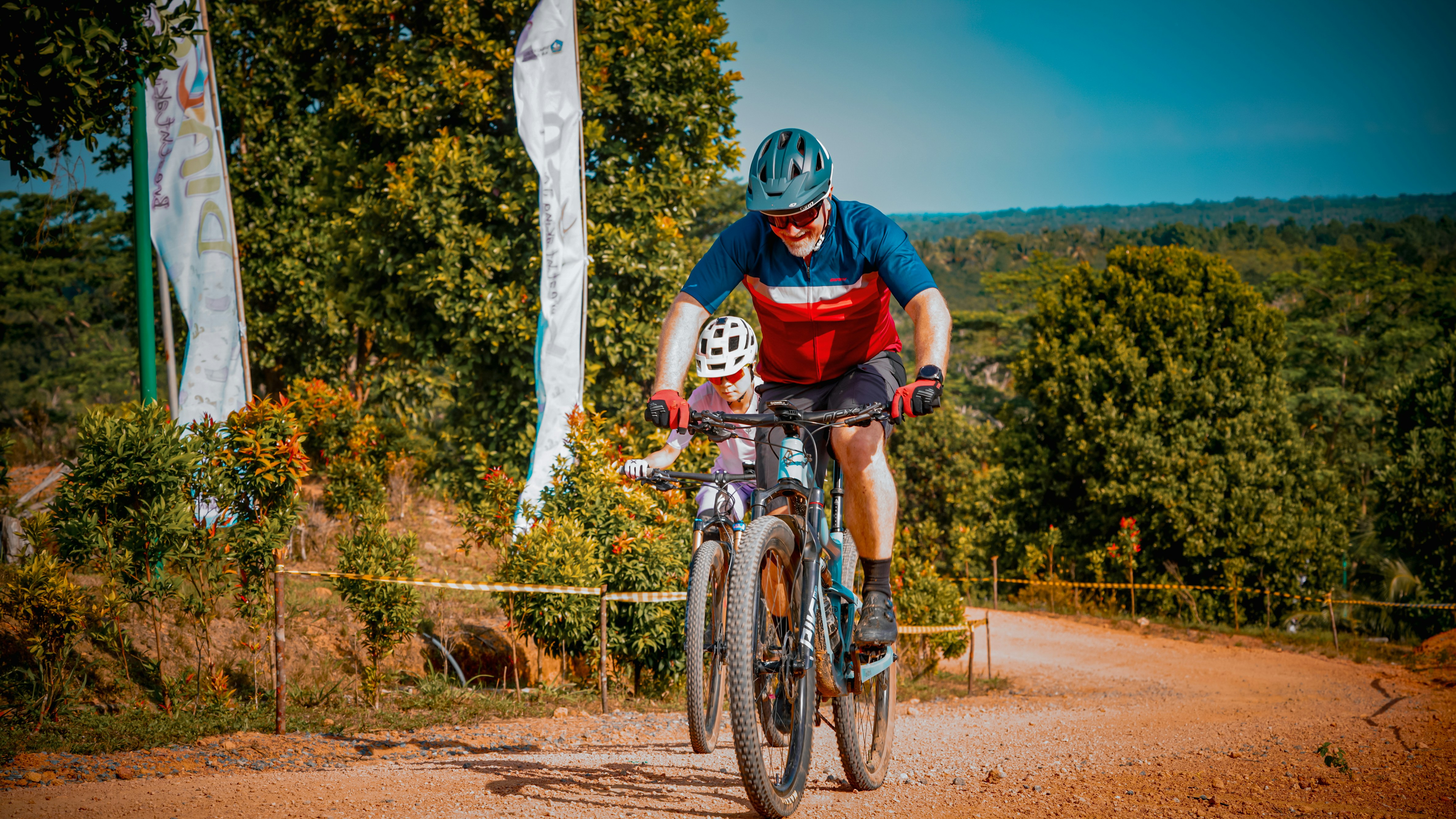 Mountain bikers ride down a dirt trail.